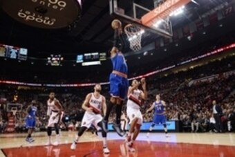 Dec 28, 2014; Portland, OR, USA; New York Knicks forward Carmelo Anthony (center) dunks the ball defended by Portland Trail Blazers center Joel Freeland (19) and forward Nicolas Batum (88) during the first quarter of the game at Moda Center at the Rose Qu
