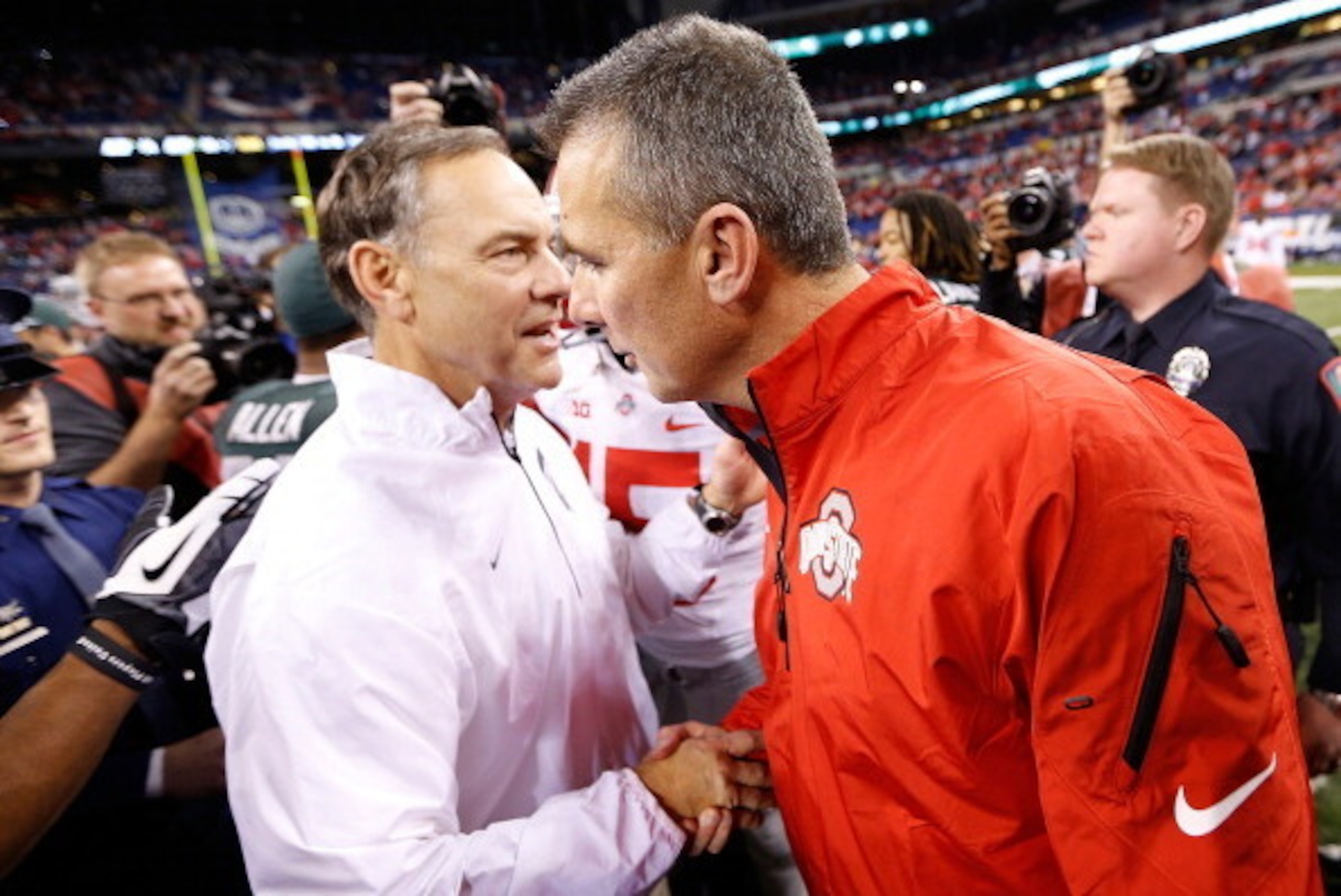 INDIANAPOLIS, IN - DECEMBER 07: Head coach Mark Dantonio of the Michigan State Spartans shakes hands with head coach Urban Meyer of the Ohio State Buckeyes after defeating the Buckeyes 34-24 to win the Big 10 Conference Championship Game at Lucas Oil Stad