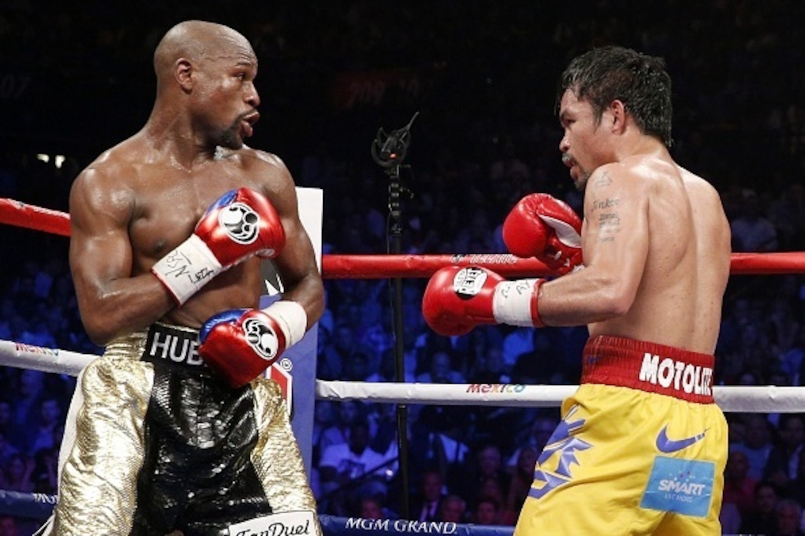 Floyd Mayweather Jr. exchange punches with Manny Pacquiao during their welterweight unification championship bout, May 2, 2015 at MGM Grand Garden Arena in Las Vegas, Nevada.  Mayweather defeated Pacquiao by unanimous decision.  AFP PHOTO / JOHN GURZINKSI