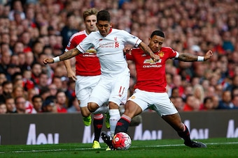 MANCHESTER, ENGLAND - SEPTEMBER 12: Roberto Firmino of Liverpool is challenged by Memphis Depay of Manchester United during the Barclays Premier League match between Manchester United and Liverpool at Old Trafford on September 12, 2015 in Manchester, Unit