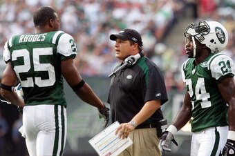 EAST RUTHERFORD, NJ - SEPTEMBER 14:  Head coach Eric Mangini of the New York Jets talks with Kerry Rhodes #25 and Darrelle Revis #24 during a time out against the New England Patriots on September 14, 2008 at Giants Stadium in East Rutherford, New Jersey.