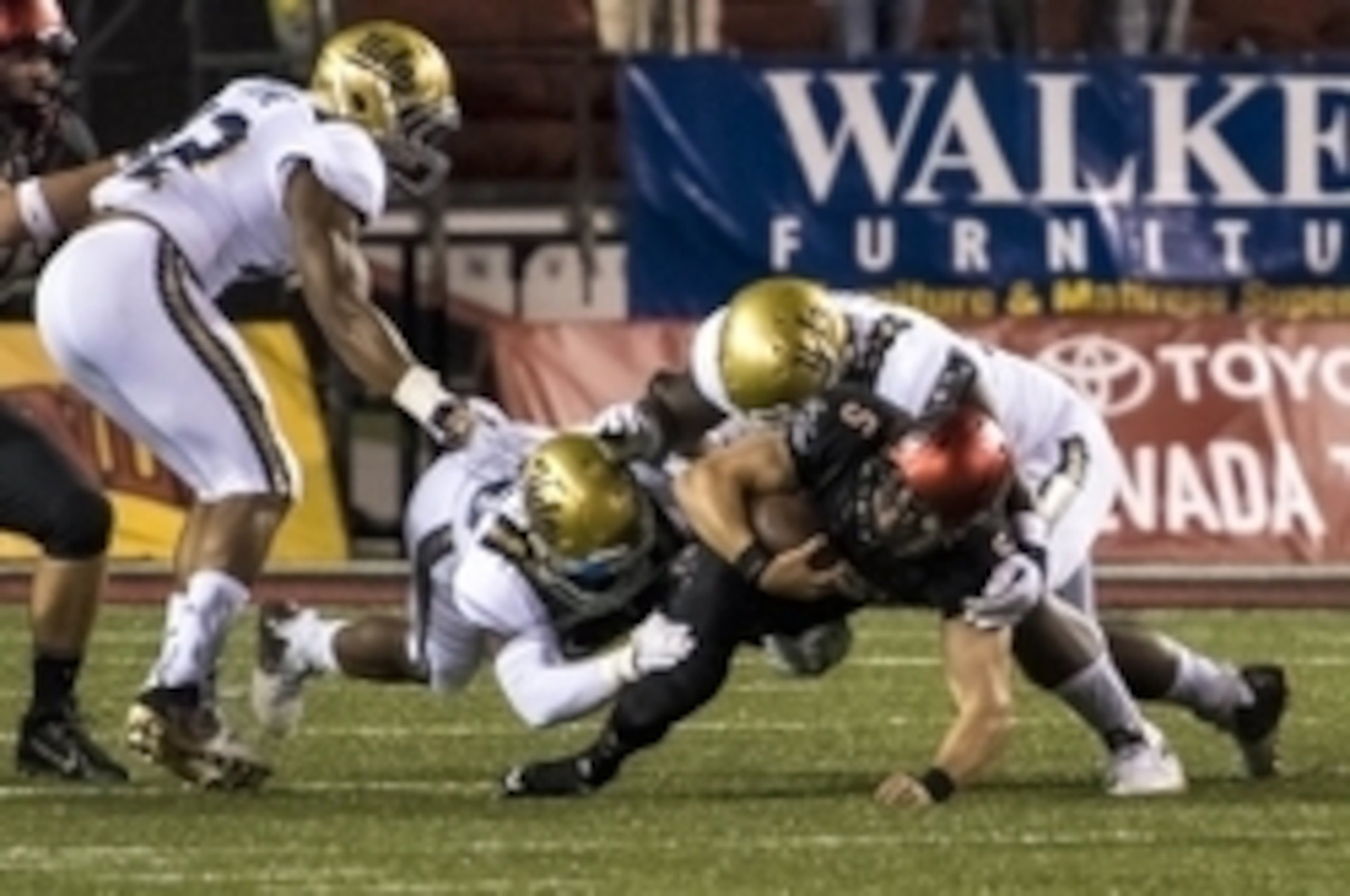Sep 12, 2015; Las Vegas, NV, USA; UNLV Rebels quarterback Blake Decker (5) is tackled by a handful of UCLA Bruins defenders during the first quarter at Sam Boyd Stadium. Mandatory Credit: Joshua Dahl-USA TODAY Sports Sep 12, 2015; Las Vegas, NV, USA; UNLV Rebels quarterback Blake Decker (5) is tackled by a handful of UCLA Bruins defenders during the first quarter at Sam Boyd Stadium. Mandatory Credit: Joshua Dahl-USA TODAY Sports