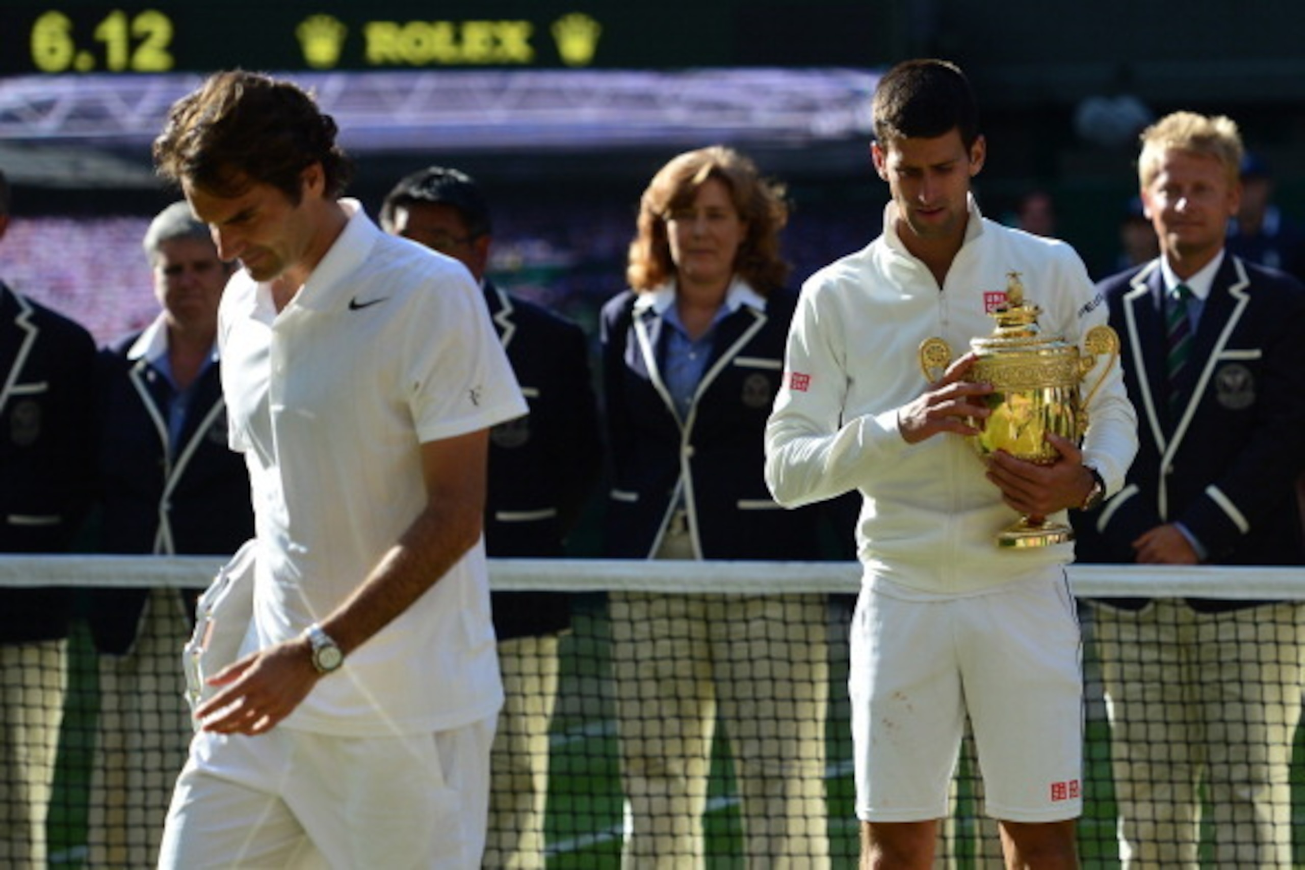 Winner Serbia's Novak Djokovic (R) and runner-up Switzerland's Roger Federer hold their trophies during the presentation at the end of their men's singles final match  on day thirteen of  the 2014 Wimbledon Championships at The All England Tennis Club in 