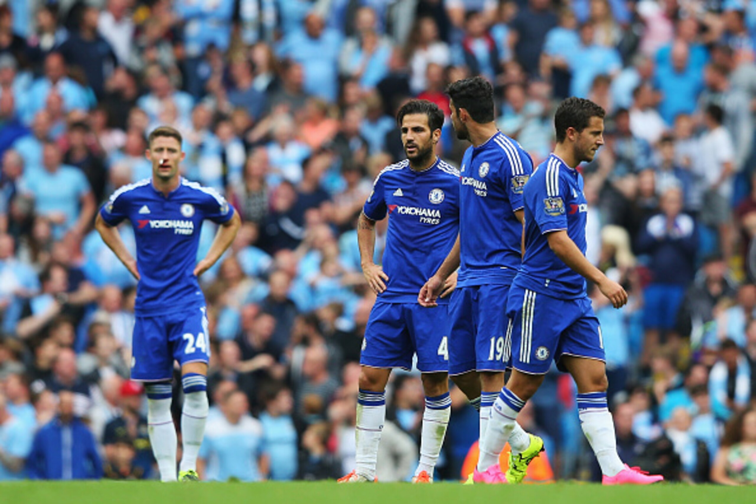 MANCHESTER, ENGLAND - AUGUST 16:  Cesc Fabregas of Chelsea looks dejected with team mates after the third Manchester City goal scored by Fernandinho of Manchester City during the Barclays Premier League match between Manchester City and Chelsea at the Eti