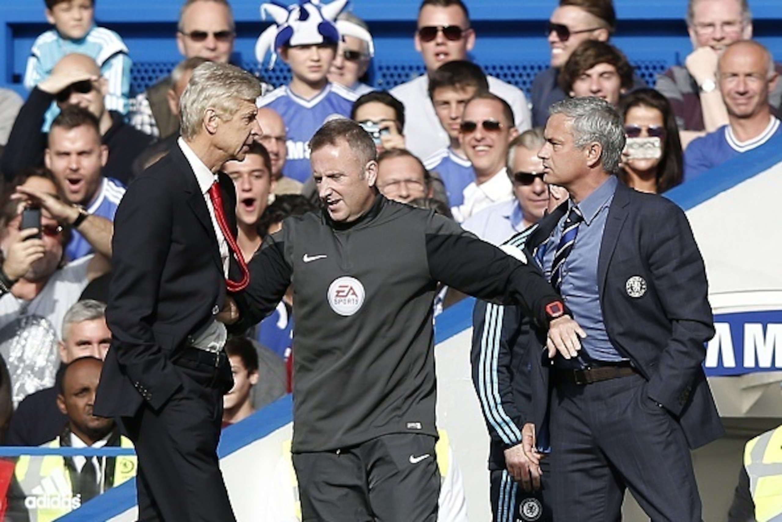 Chelsea's Portuguese manager Jose Mourinho (R) and Arsenal's French manager Arsene Wenger (L) are kept apart by the fourth official Jonathan Moss during the English Premier League football match between Chelsea and Arsenal at Stamford Bridge in London on Chelsea's Portuguese manager Jose Mourinho (R) and Arsenal's French manager Arsene Wenger (L) are kept apart by the fourth official Jonathan Moss during the English Premier League football match between Chelsea and Arsenal at Stamford Bridge in London on