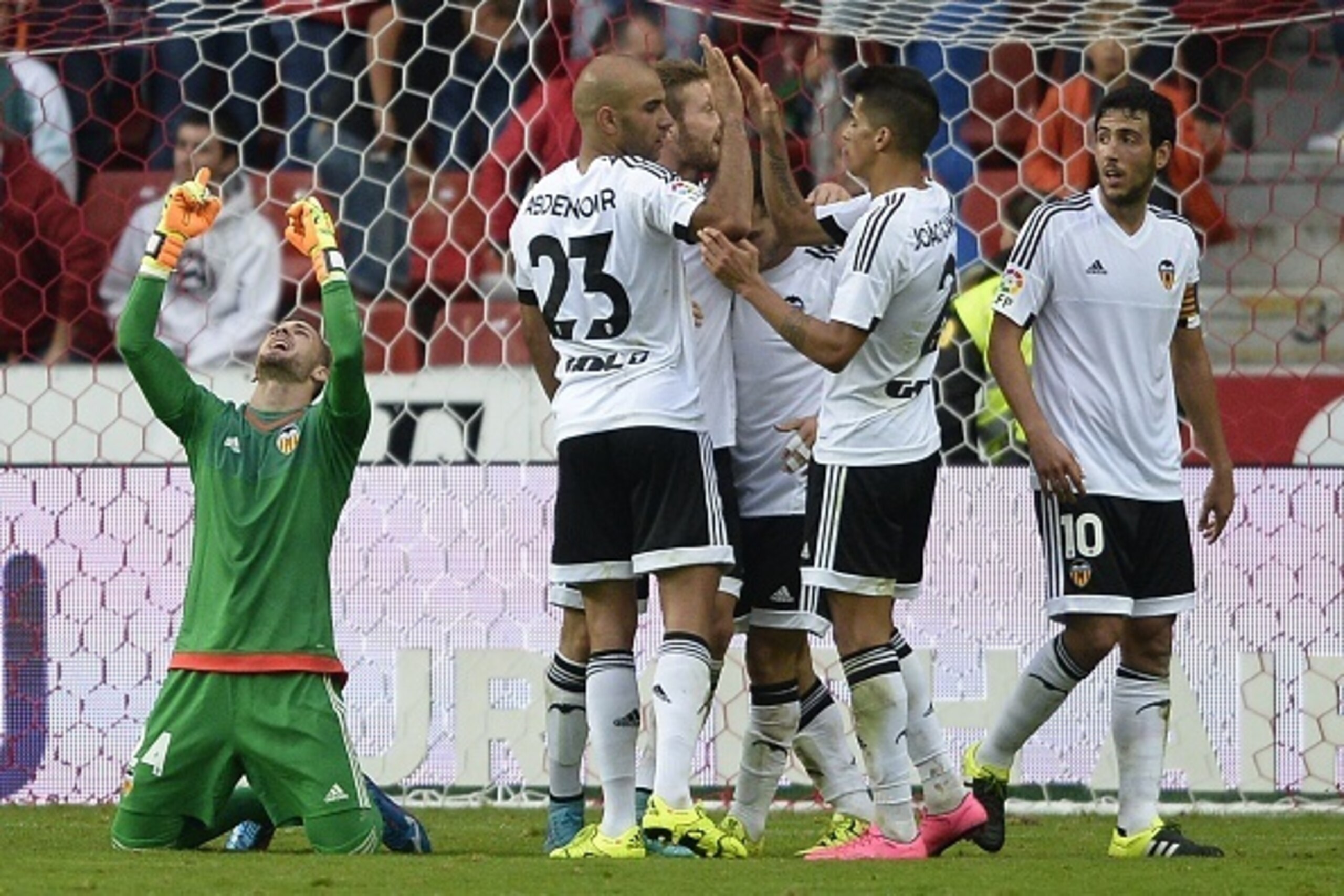 Valencia's goalkeeper Jaume Domenech (L) celebrates next to teammates at the end of the Spanish league football match Real Sporting de Gijon vs Valencia CF at El Molinon stadium in Gijon on September 12, 2015. Valencia won the match 1-0.  AFP PHOTO/ MIGUE