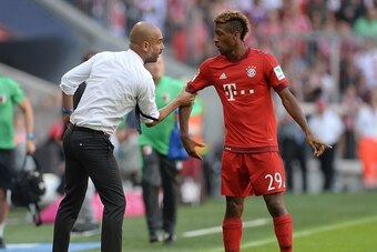 Bayern Munich's Spanish headcoach Pep Guardiola (L) talks to Bayern Munich's new French defender Kingsley Coman (R) during the German first division Bundesliga football match FC Bayern Munich v FC Augsburg, in Munich, on September 12, 2015.  AFP PHOTO /CH