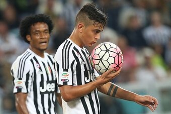 Juventus' Argentinian forward Paulo Dybala kisses the ball during the Italian Serie A  football match between Juventus and Chievo on September 12, 2015 at the Juventus Stadium in Turin.  AFP PHOTO / MARCO BERTORELLO        (Photo credit should read MARCO 