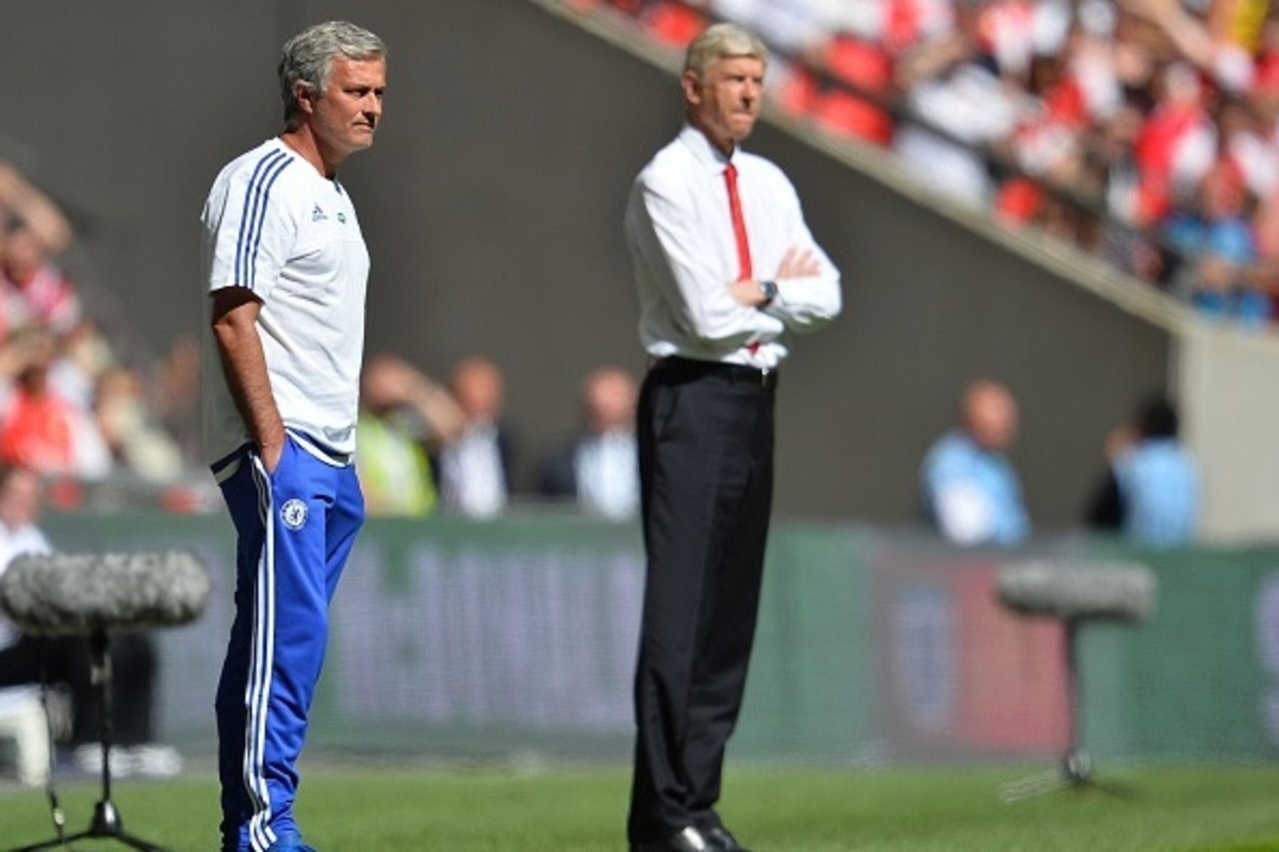 Chelsea's Portuguese manager Jose Mourinho (L) and Arsenal's French manager Arsene Wenger (R) watch from the side during the FA Community Shield football match between Arsenal and Chelsea at Wembley Stadium in north London on August 2, 2015. AFP PHOTO / G