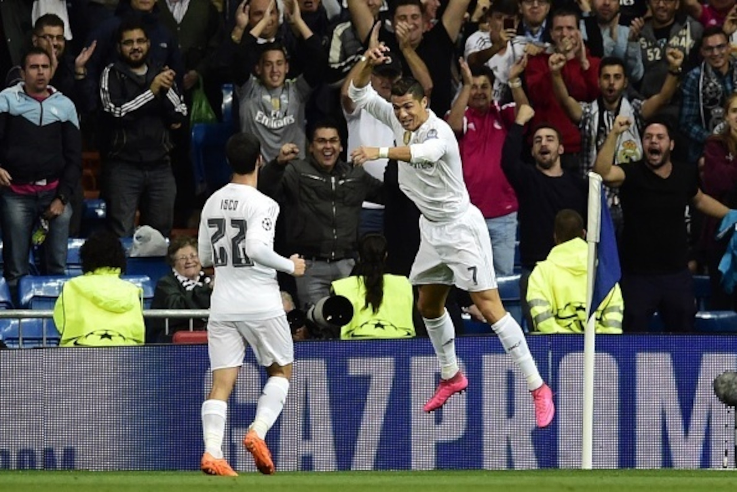 Real Madrid's Portuguese forward Cristiano Ronaldo (R) celebrates his third goal with Real Madrid's midfielder Isco during the UEFA Champions League group A football match Real Madrid CF vs FC Shakhtar Donetsk at the Santiago Bernabeu stadium in Madrid on