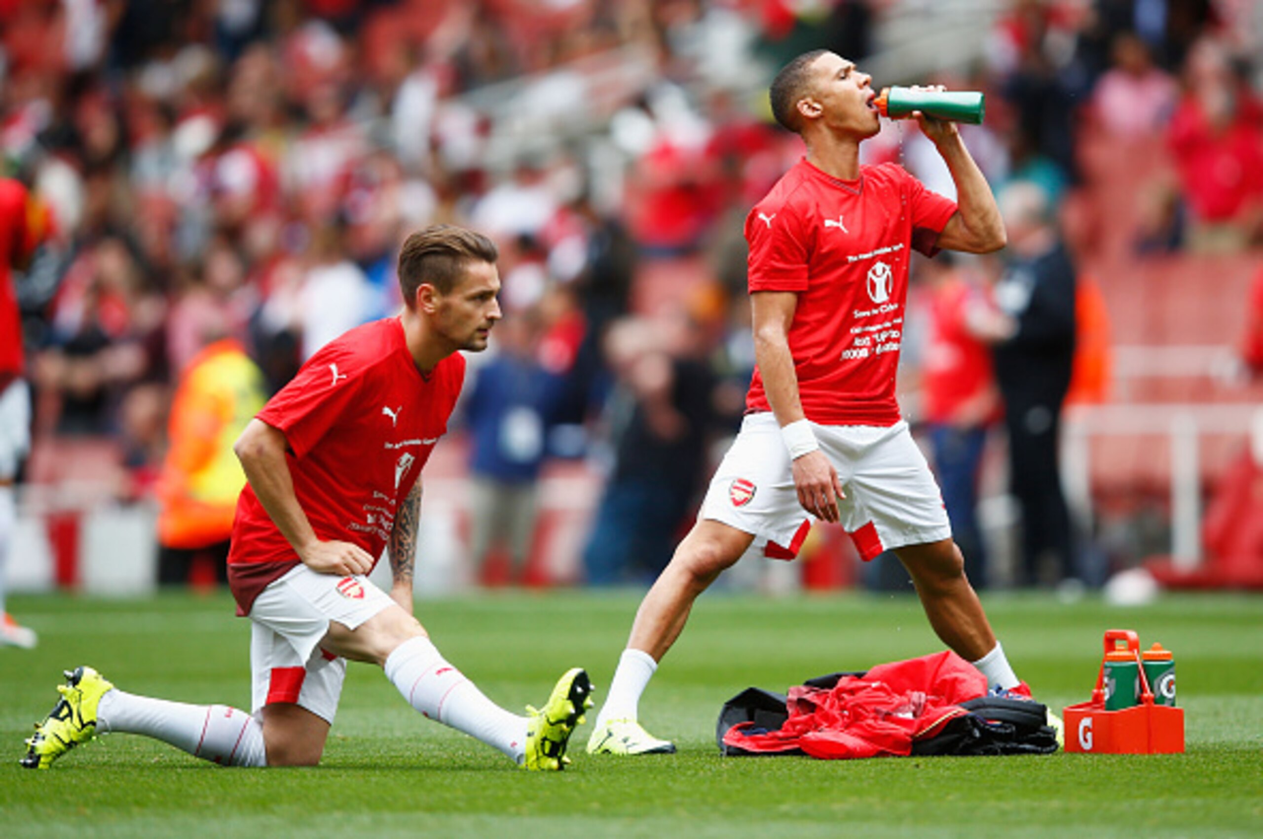 LONDON, ENGLAND - SEPTEMBER 12: Mathieu Debuchy and Kieran Gibbs (R) of Arsenal wear 'Save the Children' shirts prior to the Barclays Premier League match between Arsenal and Stoke City at the Emirates Stadium on September 12, 2015 in London, United Kingd