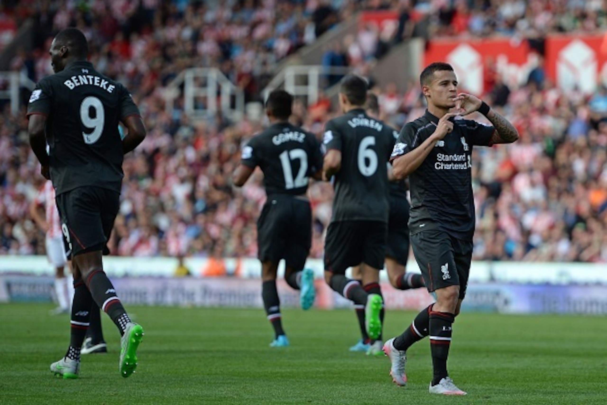 Liverpool's Brazilian midfielder Philippe Coutinho (R) celebrates after scoring the opening goal of the English Premier League football match between Stoke City and Liverpool at the Britannia Stadium in Stoke-on-Trent, central England on August 9, 2015. L