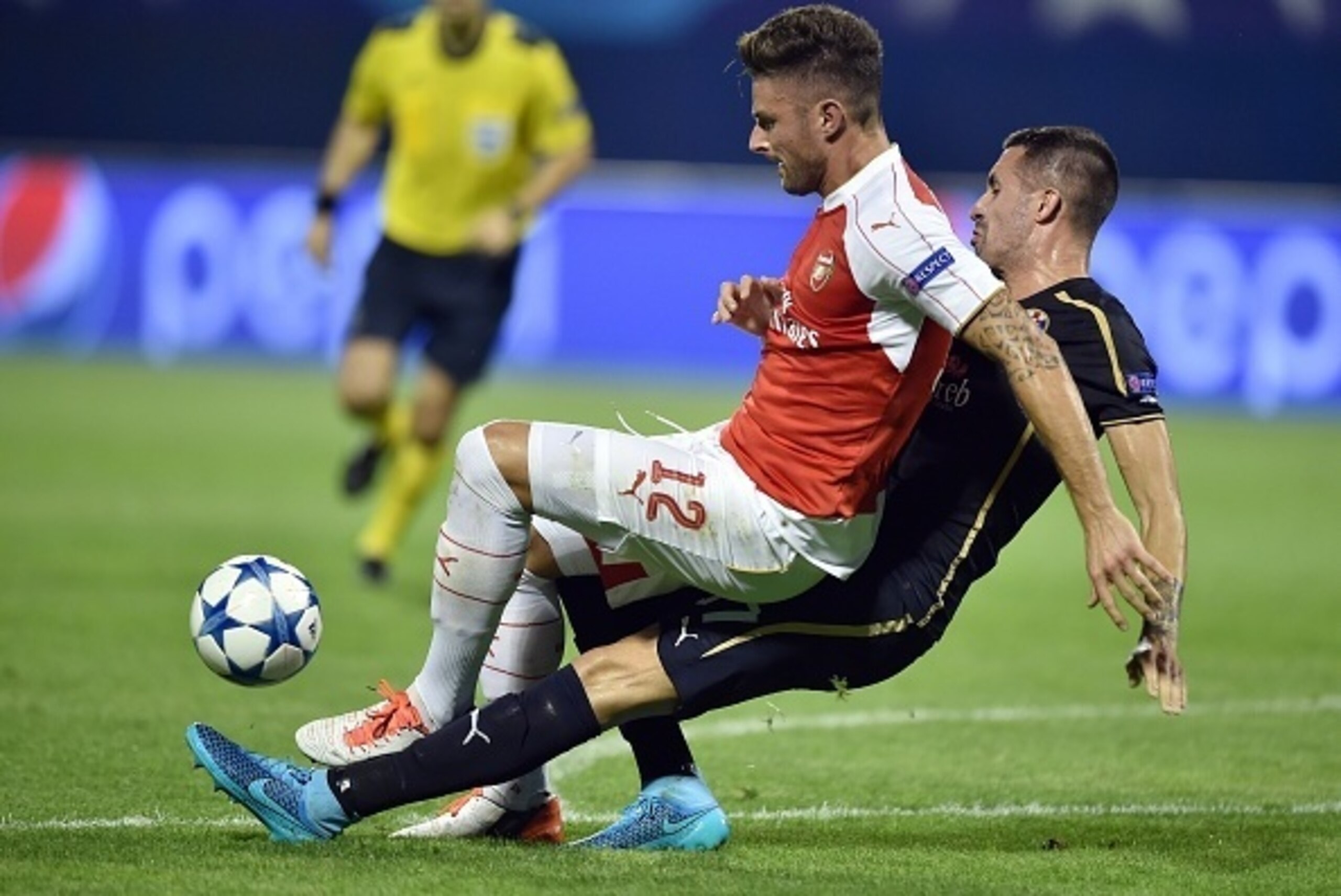 Arsenal's French forward Olivier Giroud (L) vies with Dinamo Zagreb's Macedonian midfielder Arijan Ademi (R) during the UEFA Champions League Group F football match between GNK Dinamo Zagreb and Arsenal FC at Maksimir Stadium in Zagreb on September 16, 20