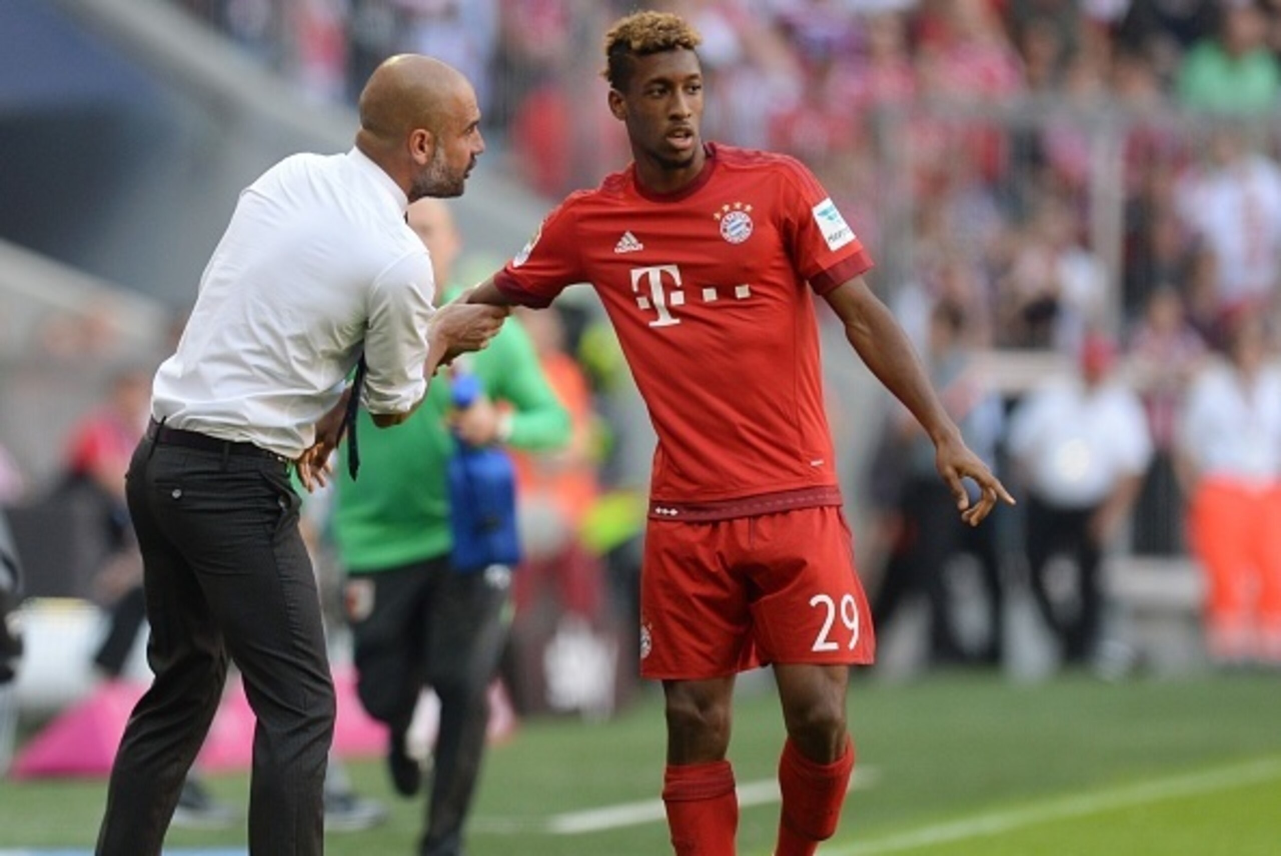 Bayern Munich's Spanish headcoach Pep Guardiola (L) talks to Bayern Munich's new French defender Kingsley Coman (R) during the German first division Bundesliga football match FC Bayern Munich v FC Augsburg, in Munich, on September 12, 2015.  AFP PHOTO /CH