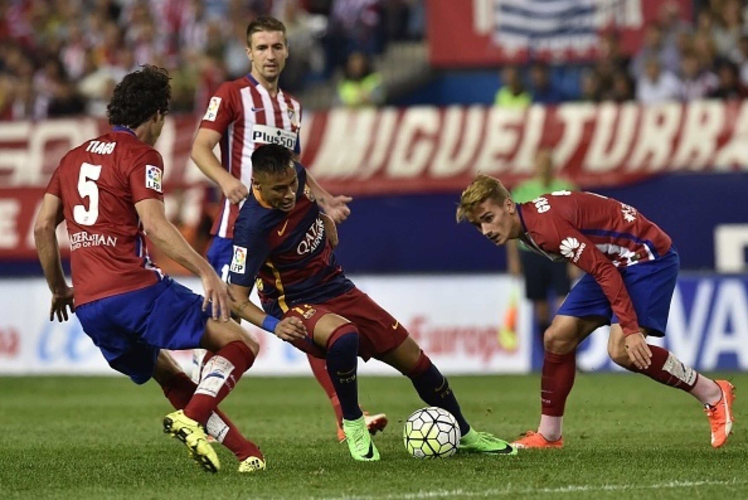 Barcelona's Brazilian forward Neymar (C) vies with Atletico Madrid's French forward Antoine Griezmann (R) during the Spanish league football match Club Atletico de Madrid vs FC Barcelona at the Vicente Calderon stadium in Madrid on September 12, 2015.   A
