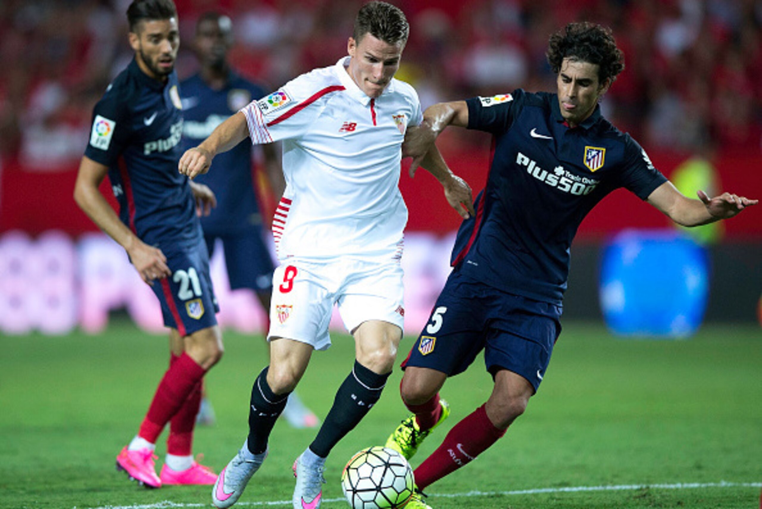 SEVILLE, SPAIN - AUGUST 30: Kevin Gameiro (2ndL) of Sevilla FC competes for the ball with Tiago Mendes (R) of Atletico de Madrid and his teammate Yannick Carrasco during the La Liga match between Sevilla FC and Club Atletico de Madrid at Estadio Ramon San