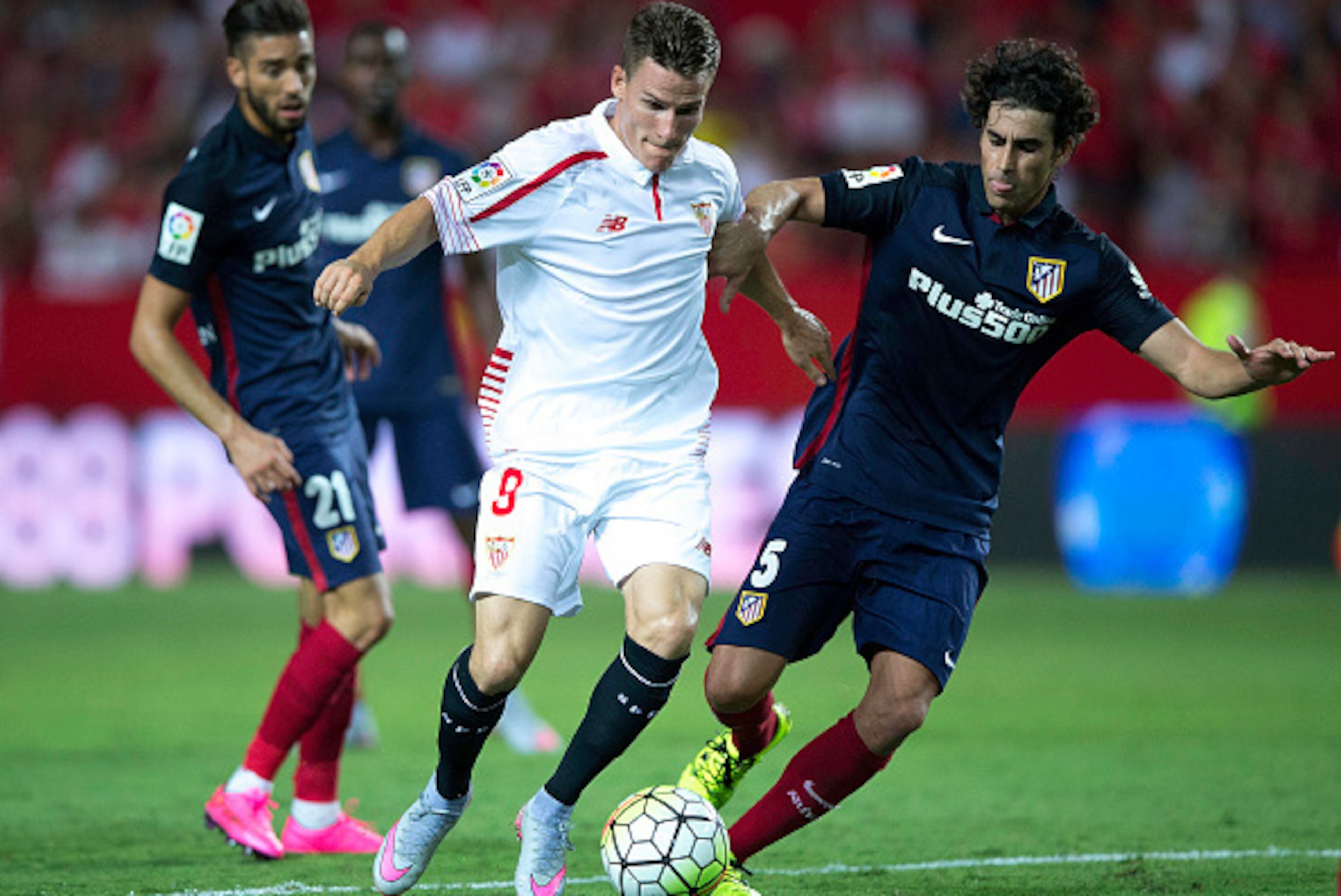 SEVILLE, SPAIN - AUGUST 30: Kevin Gameiro (2ndL) of Sevilla FC competes for the ball with Tiago Mendes (R) of Atletico de Madrid and his teammate Yannick Carrasco during the La Liga match between Sevilla FC and Club Atletico de Madrid at Estadio Ramon San