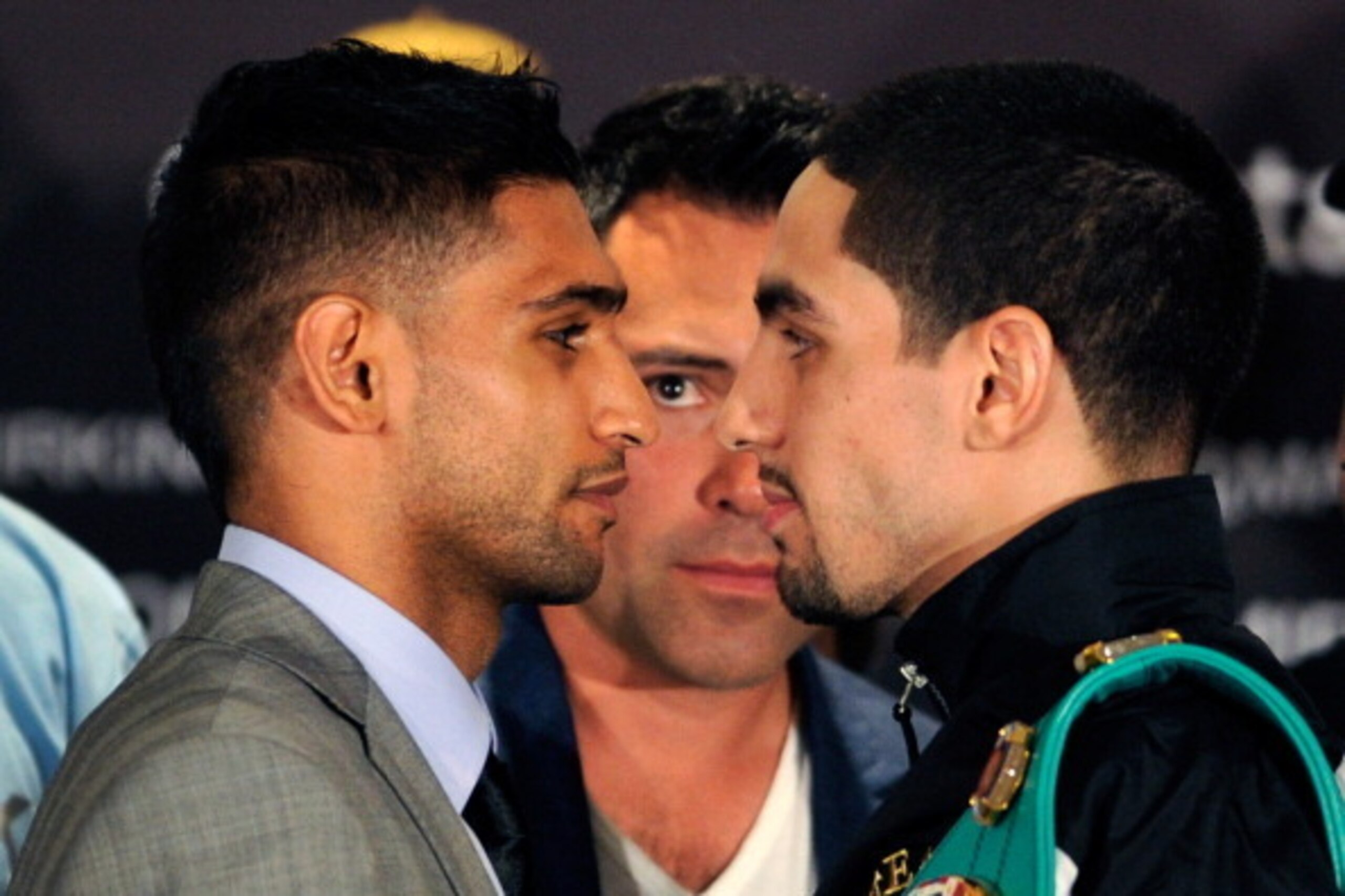 LAS VEGAS, NV - JULY 12:  President of Golden Boy Promotions Oscar De La Hoya (C) keeps an eye on boxers Amir Khan (L) and Danny Garcia during the face off at the final news conference at the Mandalay Bay Resort & Casino on July 12, 2012 in Las Vegas, Nev