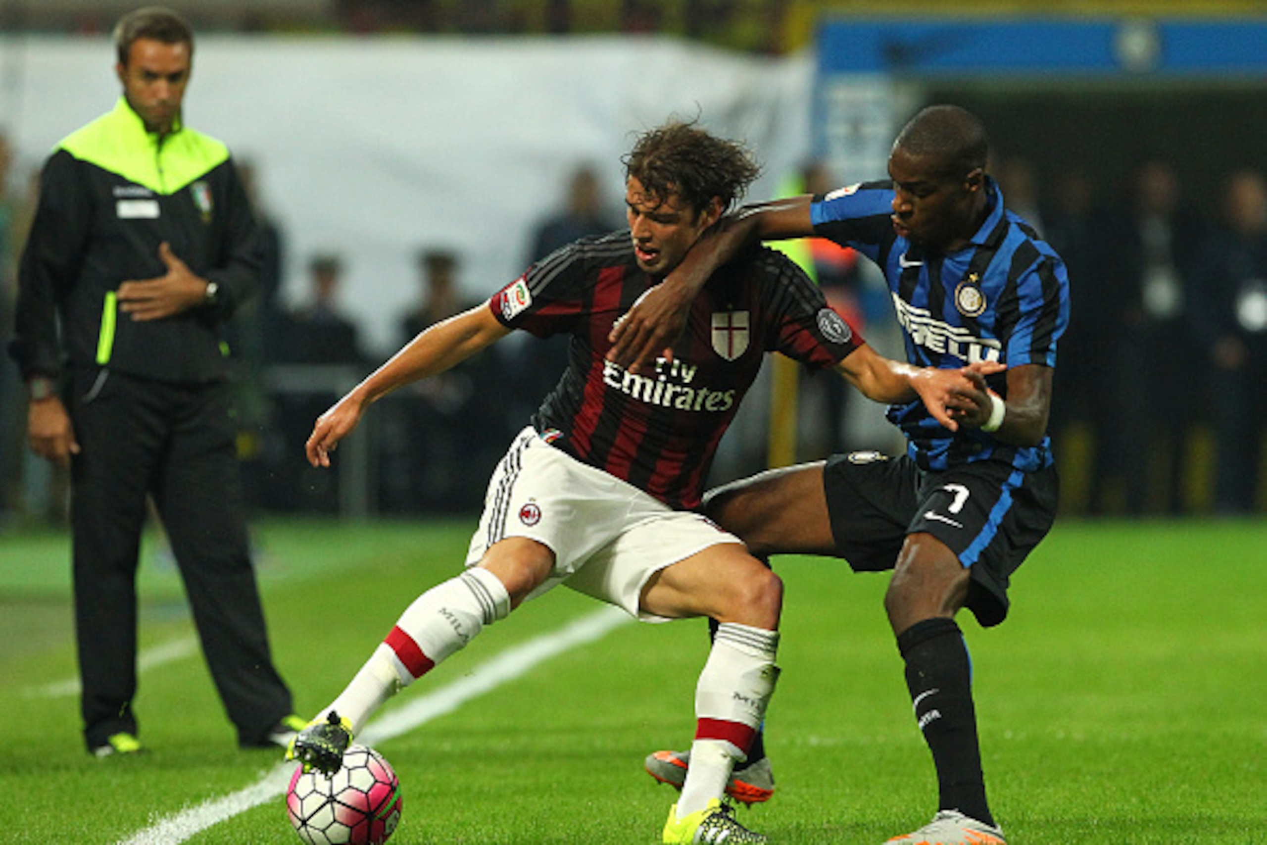 MILAN, ITALY - SEPTEMBER 13:  Andrea Poli of AC Milan competes for the ball with Geoffrey Kondogbia of FC Internazionale Milano during the Serie A match between FC Internazionale Milano and AC Milan at Stadio Giuseppe Meazza on September 13, 2015 in Milan