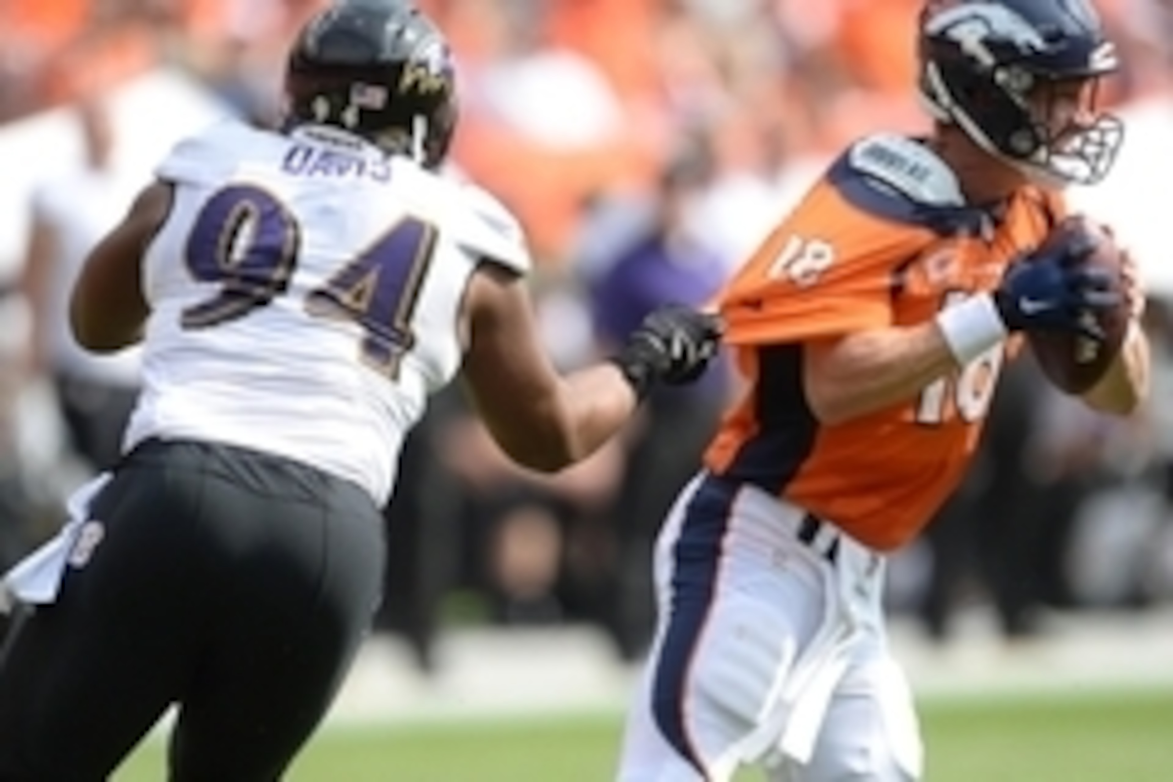 Sep 13, 2015; Denver, CO, USA; Baltimore Ravens defensive tackle Carl Davis (94) grabs onto Denver Broncos quarterback Peyton Manning (18) in the second quarter at Sports Authority Field at Mile High. Mandatory Credit: Ron Chenoy-USA TODAY Sports