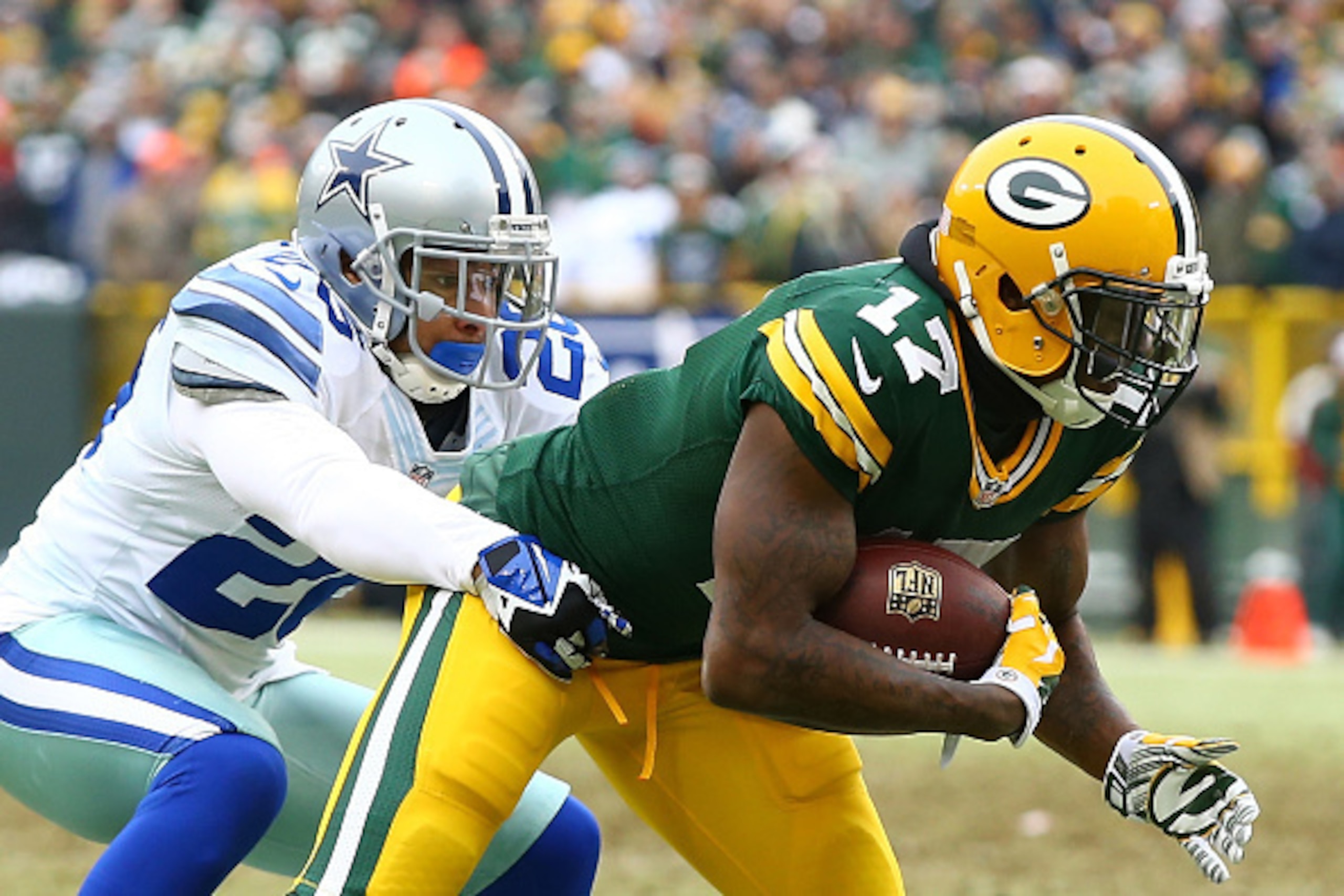 GREEN BAY, WI - JANUARY 11:   Davante Adams #17 of the Green Bay Packers is tackled by   Sterling Moore #26 of the Dallas Cowboys during the 2015 NFC Divisional Playoff game at Lambeau Field on January 11, 2015 in Green Bay, Wisconsin.  (Photo by Al Bello