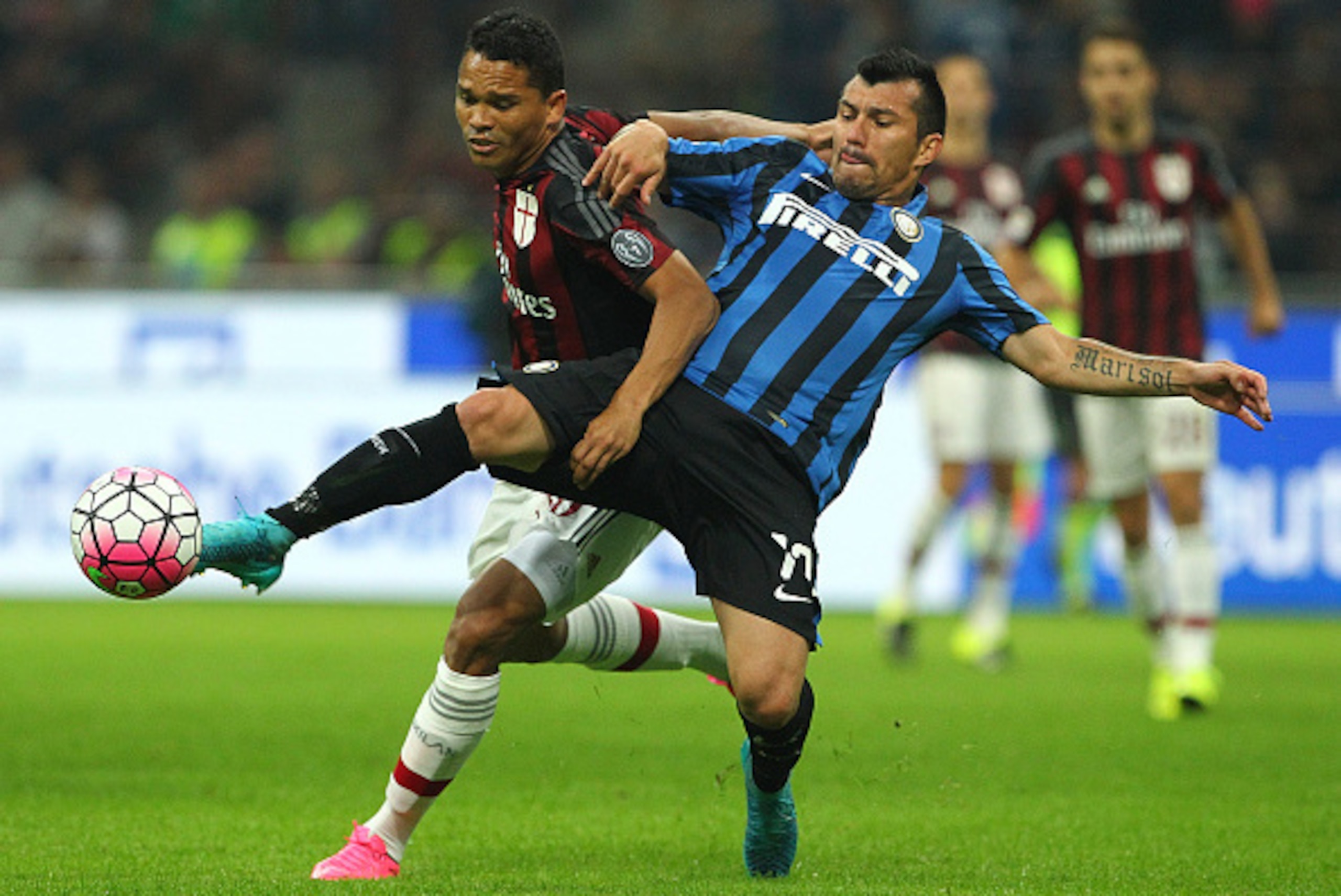 MILAN, ITALY - SEPTEMBER 13:  Carlos Bacca of AC Milan competes for the ball with Gary Alexis Medel of FC Internazionale Milano during the Serie A match between FC Internazionale Milano and AC Milan at Stadio Giuseppe Meazza on September 13, 2015 in Milan