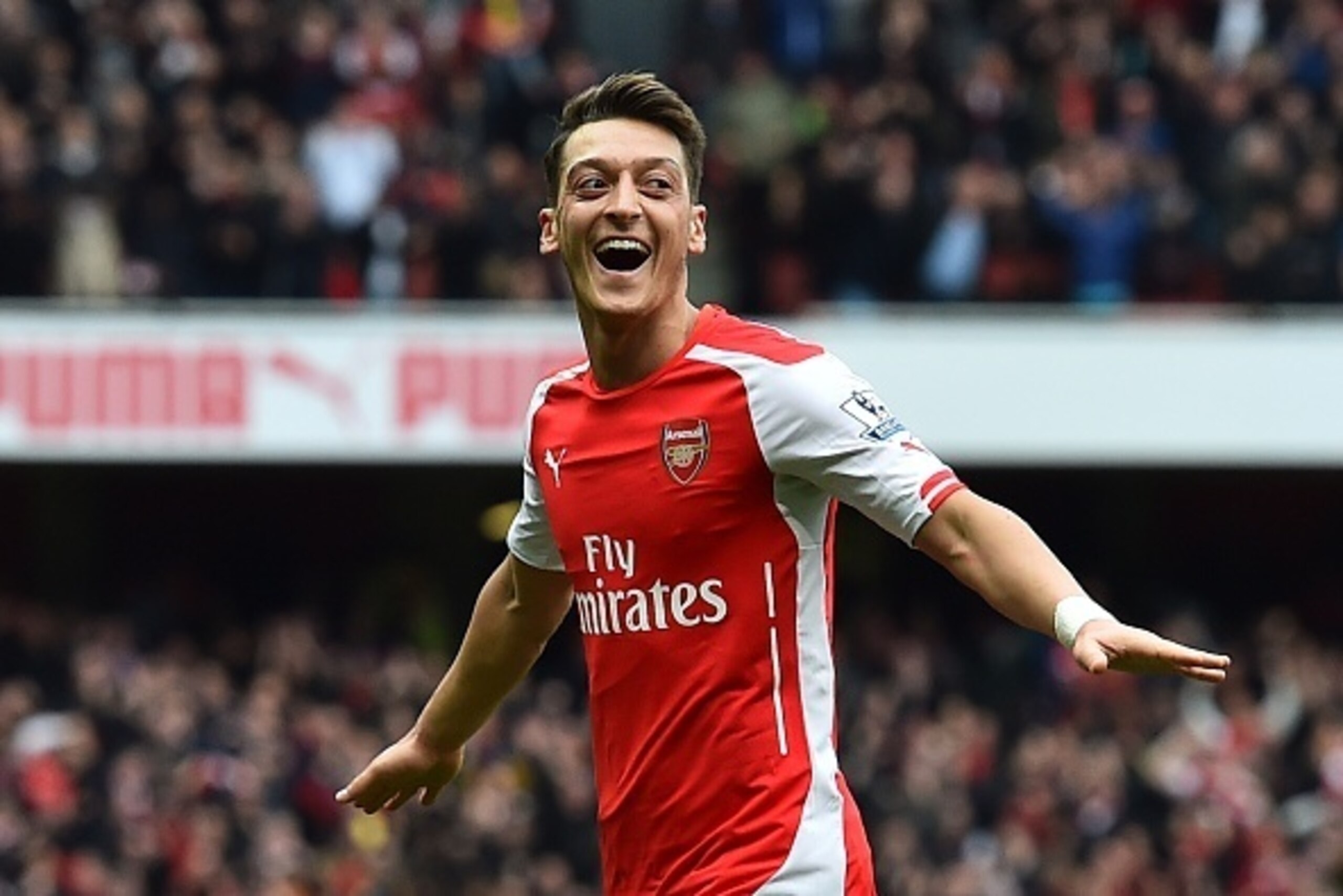 Arsenal's German midfielder Mesut Ozil celebrates after scoring their second goal during the English Premier League football match between Arsenal and Liverpool at the Emirates Stadium in London on April 4, 2015. AFP PHOTO / BEN STANSALL

RESTRICTED TO ED