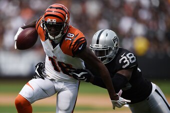 OAKLAND, CA - SEPTEMBER 13:  A.J. Green #18 of the Cincinnati Bengals is tackled by TJ Carrie #38 of the Oakland Raiders during the first half of their NFL game at O.co Coliseum on September 13, 2015 in Oakland, California.  (Photo by Thearon W. Henderson