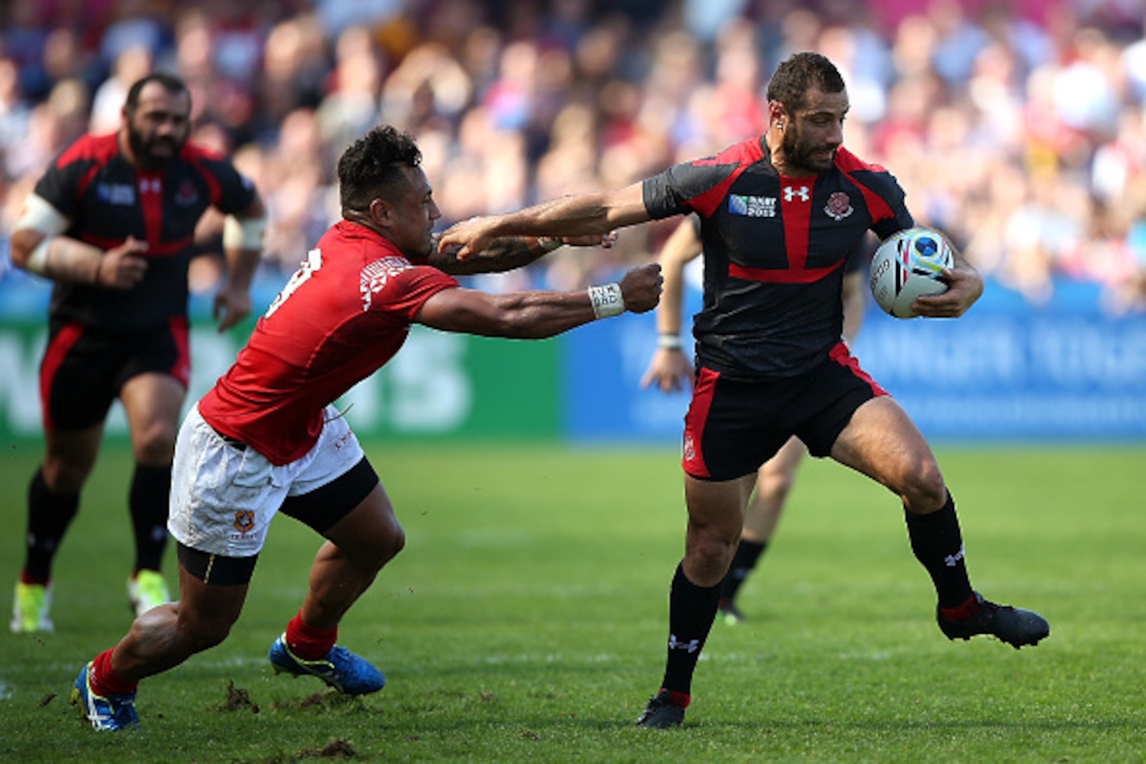 GLOUCESTER, ENGLAND - SEPTEMBER 19: Lasha Malaguradze of Georgia hands off the tackle of Sonatane Takulua of Tonga during the 2015 Rugby World Cup Pool C match between Tonga and Georgia at Kingsholm Stadium on September 19, 2015 in Gloucester, United Kin GLOUCESTER, ENGLAND - SEPTEMBER 19: Lasha Malaguradze of Georgia hands off the tackle of Sonatane Takulua of Tonga during the 2015 Rugby World Cup Pool C match between Tonga and Georgia at Kingsholm Stadium on September 19, 2015 in Gloucester, United Kin