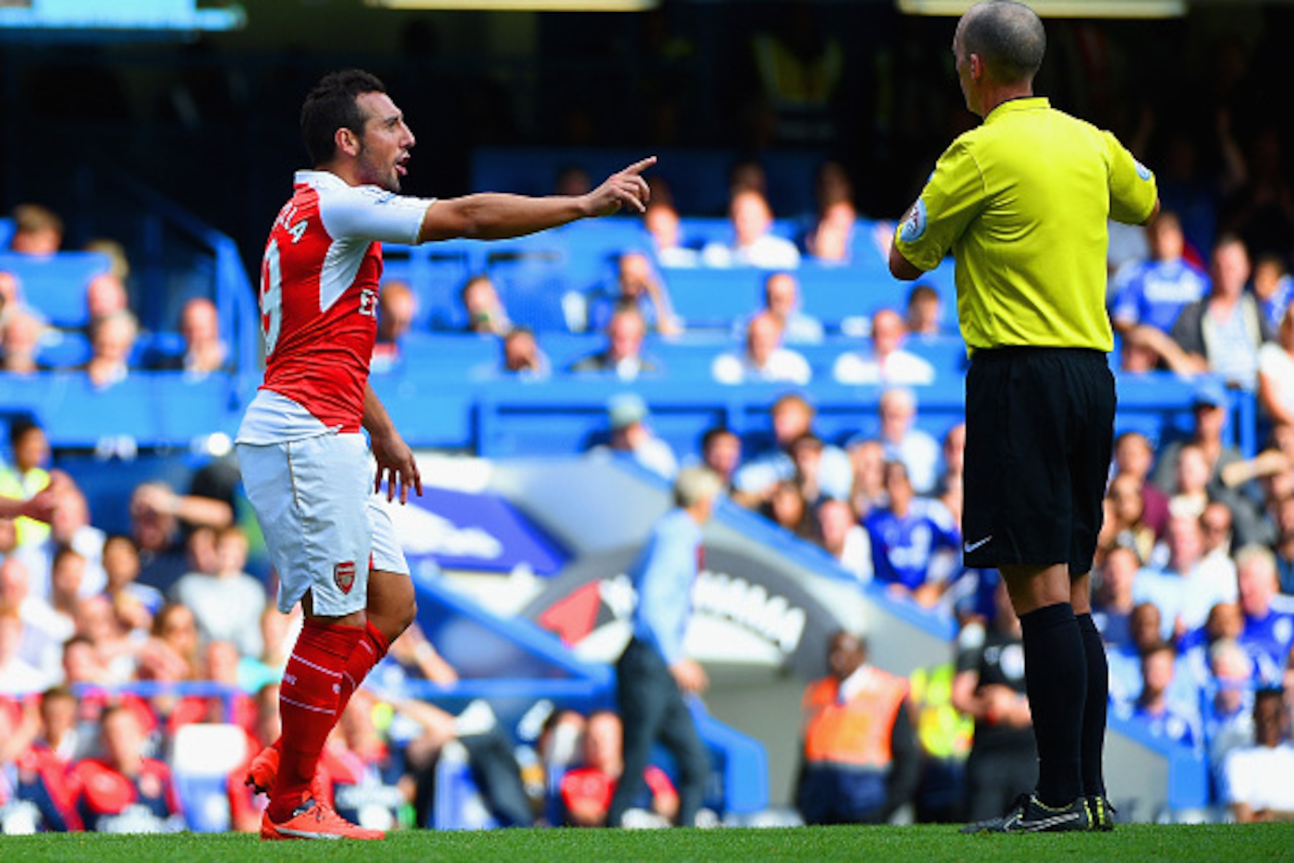 LONDON, ENGLAND - SEPTEMBER 19: Referee Mike Dean prepares to show the second yellow card to  Santi Cazorla of Arsenal during the Barclays Premier League match between Chelsea and Arsenal at Stamford Bridge on September 19, 2015 in London, United Kingdom.