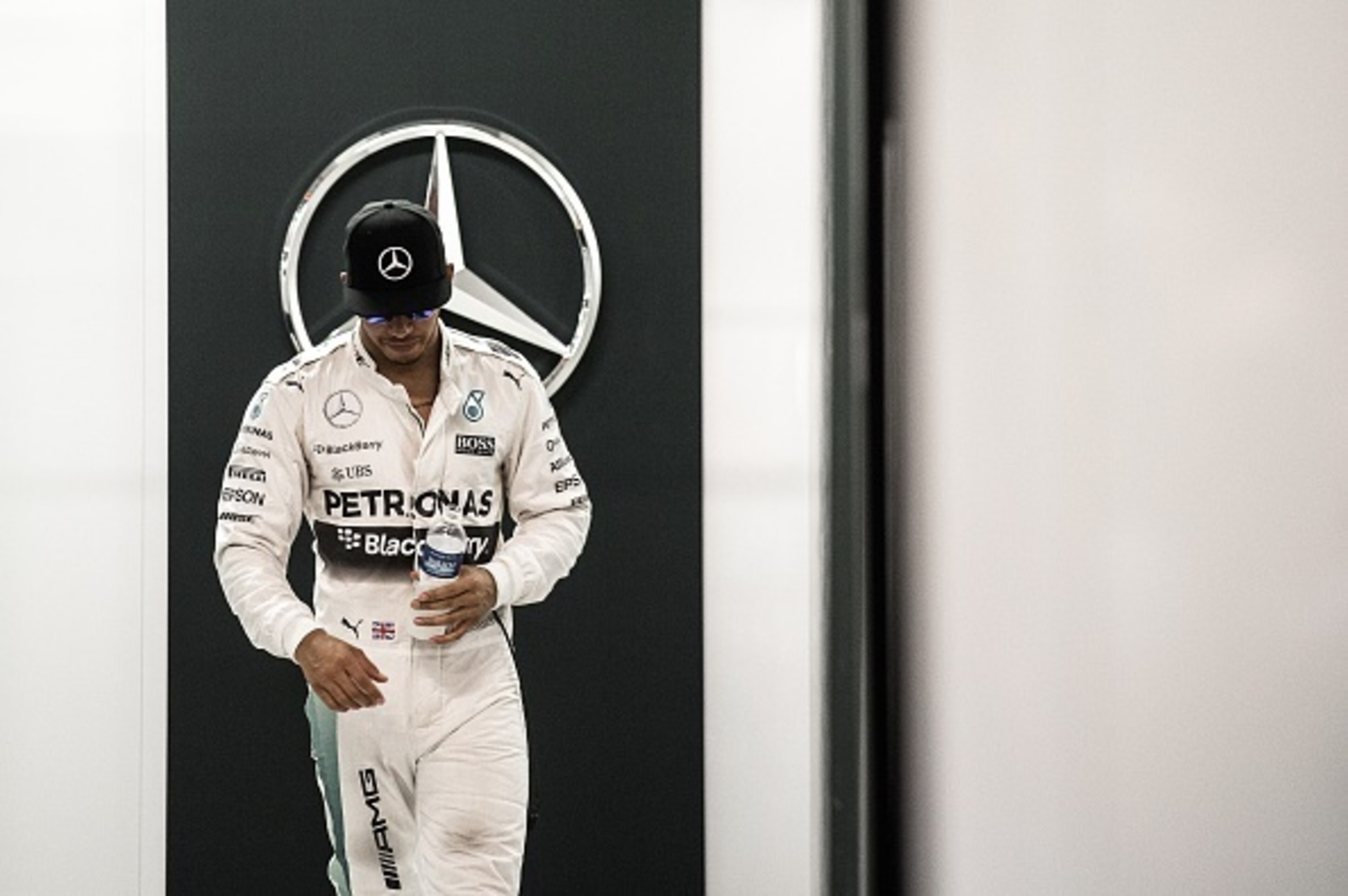 Mercedes AMG Petronas F1 Team's British driver Lewis Hamilton walks out of the garage after the third and final free practice session of the Formula One Singapore Grand Prix in Singapore on September 19, 2015.    AFP PHOTO / Philippe Lopez        (Photo c
