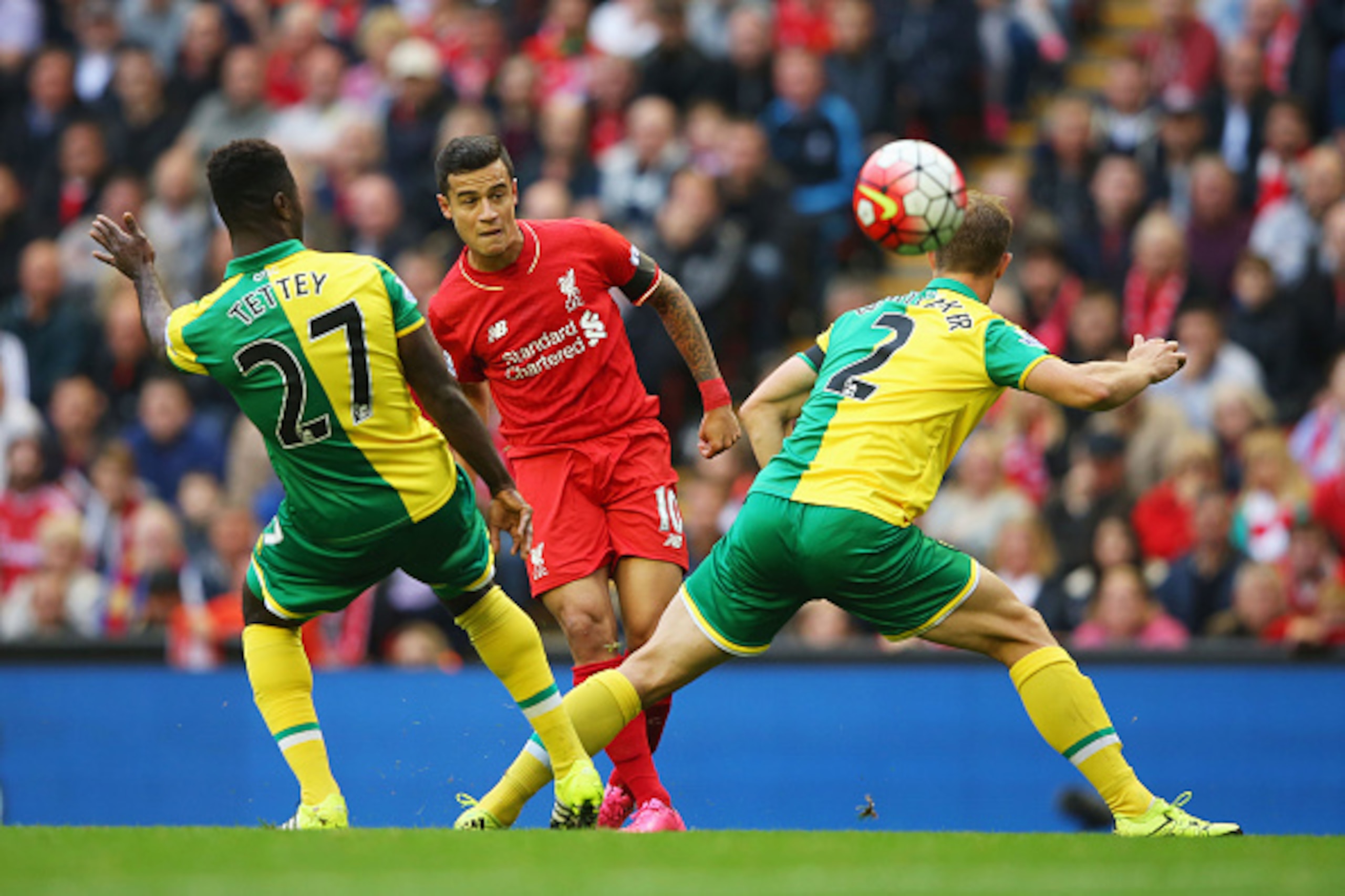 LIVERPOOL, ENGLAND - SEPTEMBER 20:  Philippe Coutinho of Liverpool shoots past Alexander Tettey (27) and Steven Whittaker of Norwich City (2) during the Barclays Premier League match between Liverpool and Norwich City at Anfield on September 20, 2015 in L