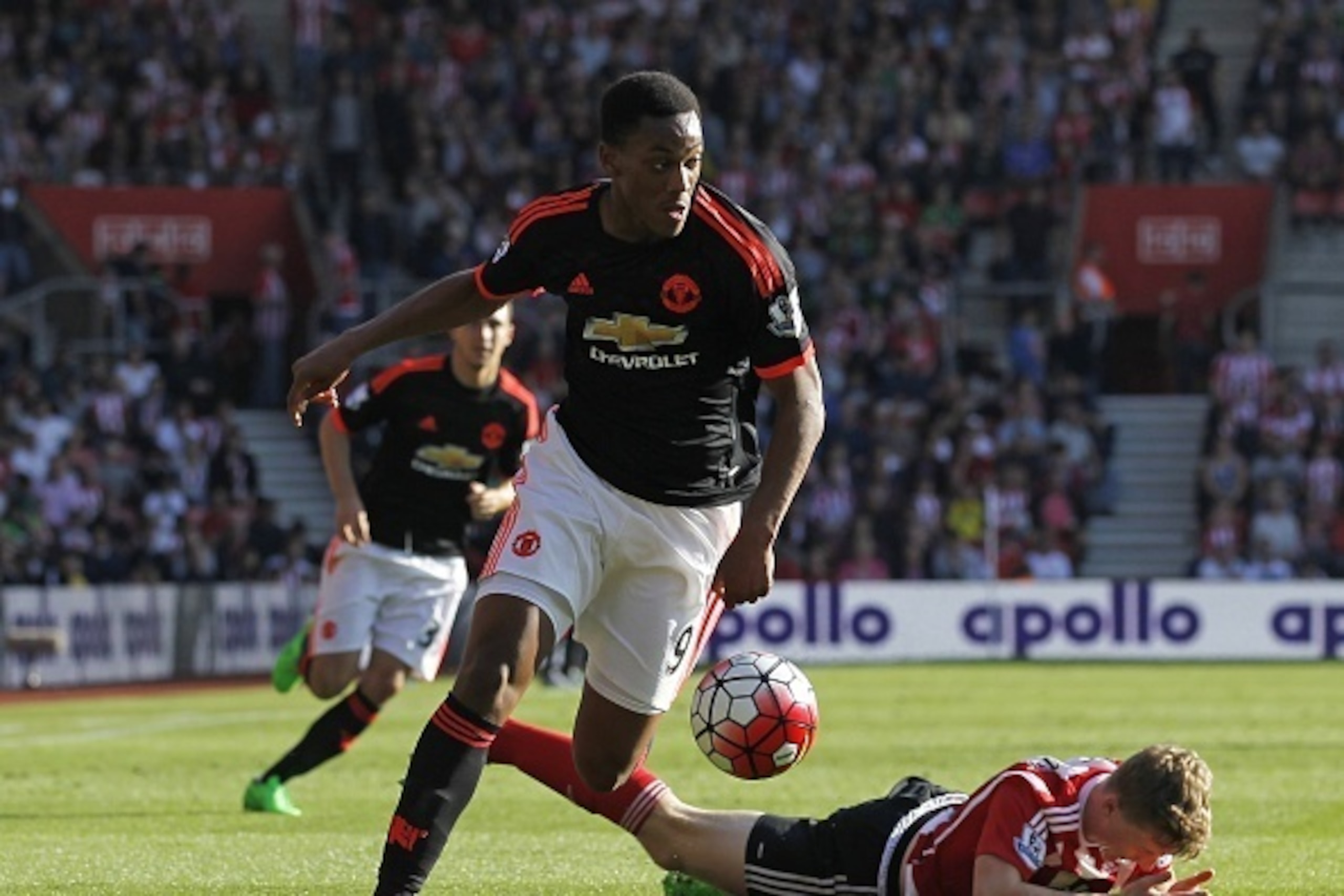 Manchester United's French striker Anthony Martial runs with the ball as Southampton's English defender Matt Targett (R) lies injured during the English Premier League football match between Southampton and Manchester United at St Mary's Stadium in Southa