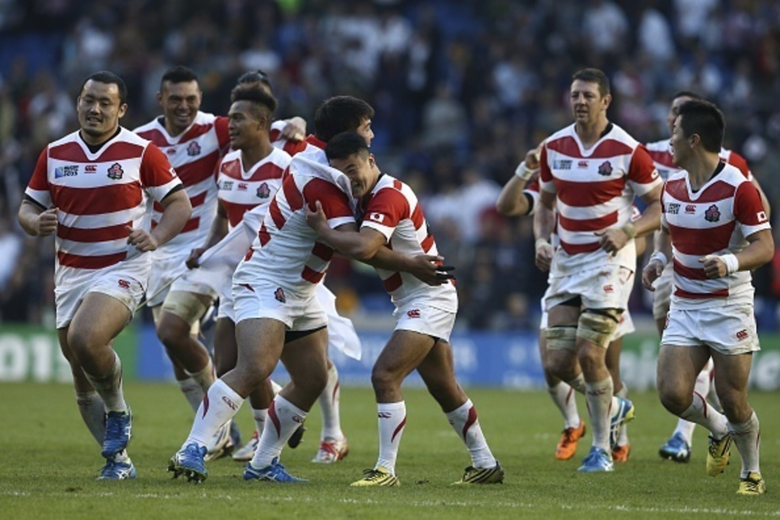 Japan's prop Kensuke Hatakeyama (CL) embraces Japan's scrum half Atsushi Hiwasa (CR) after winning the Pool B match of the 2015 Rugby World Cup between South Africa and Japan at the Brighton community stadium in Brighton, south east England on September 1