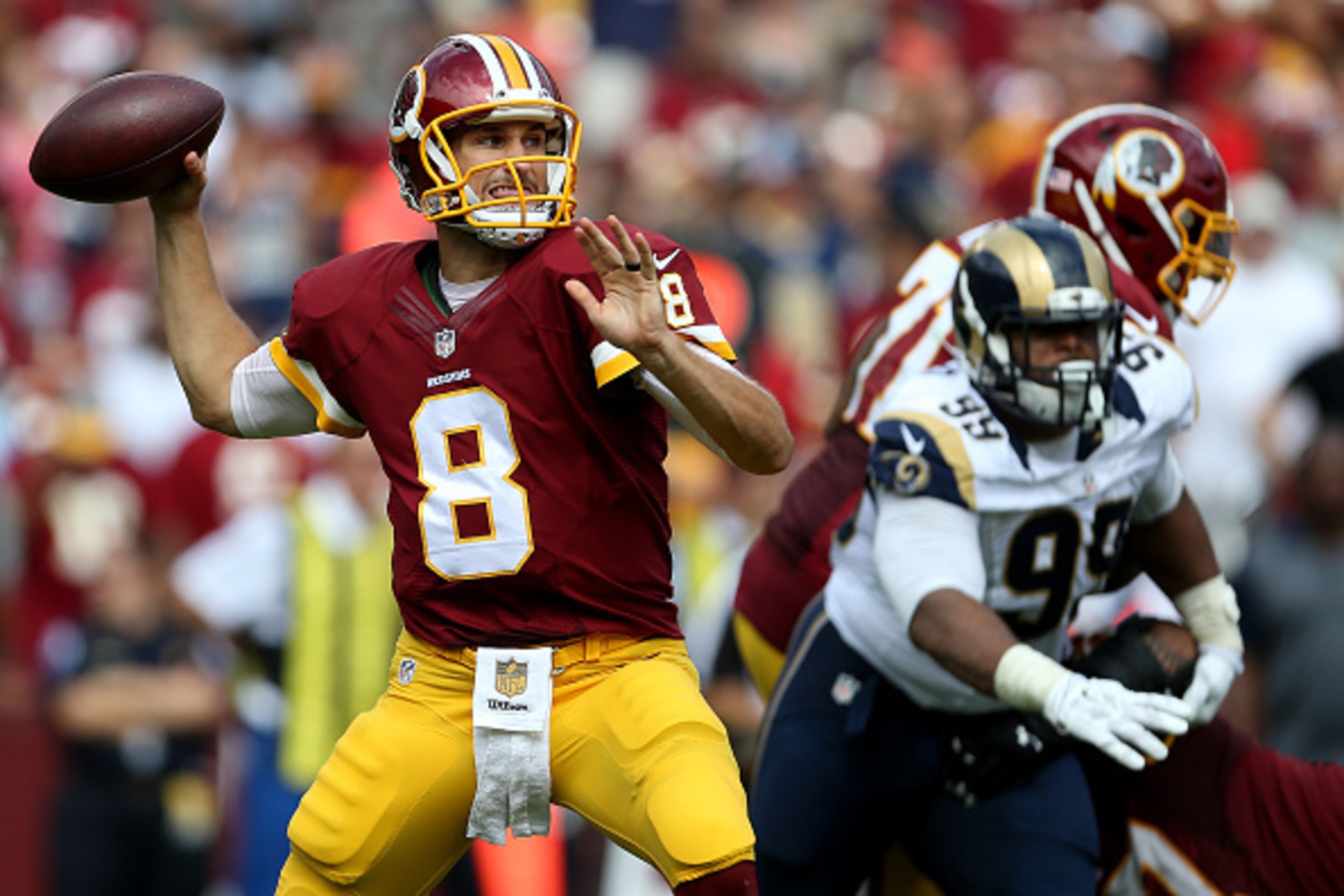 LANDOVER, MD - SEPTEMBER 20: Quarterback Kirk Cousins #8 of the Washington Redskins drops back to pass while defensive tackle Aaron Donald #99 of the St. Louis Rams defends in the third quarter of a game at FedExField on September 20, 2015 in Landover, Ma