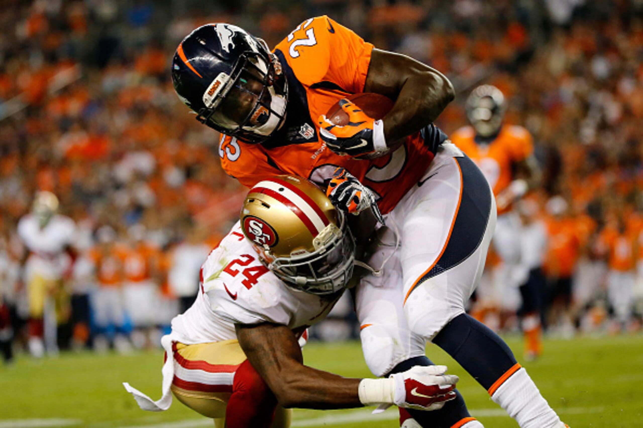 DENVER, CO - AUGUST 29:  Running back Ronnie Hillman #23 of the Denver Broncos carries the ball against the defense of defensive back Shareece Wright #24 of the San Francisco 49ers during preseason action at Sports Authority Field at Mile High on August 2