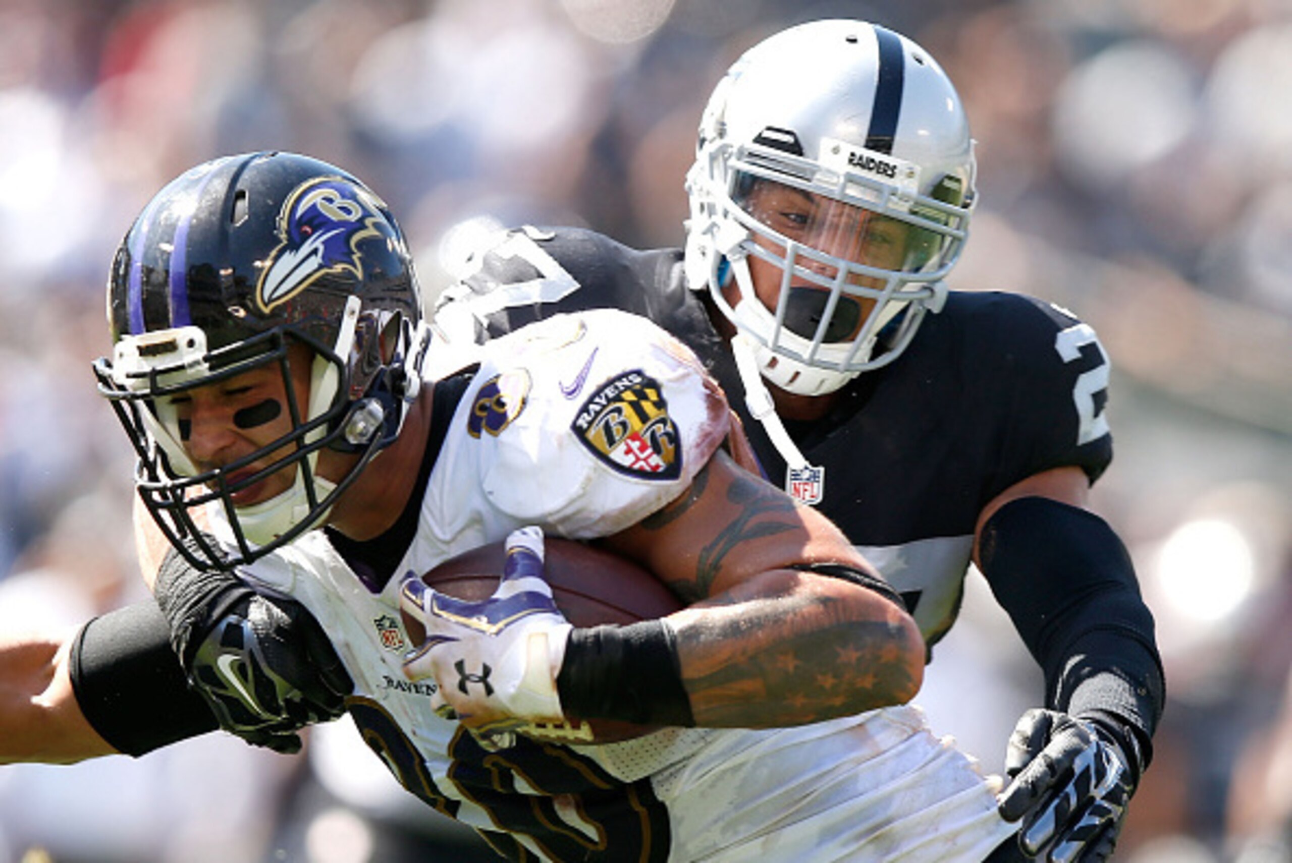 OAKLAND, CA - SEPTEMBER 20:  Crockett Gillmore #80 of the Baltimore Ravens carries for a touchdown against the block of Taylor Mays #27 of the Oakland Raiders in the second quarter against the Oakland Raiders at Oakland-Alameda County Coliseum on Septembe