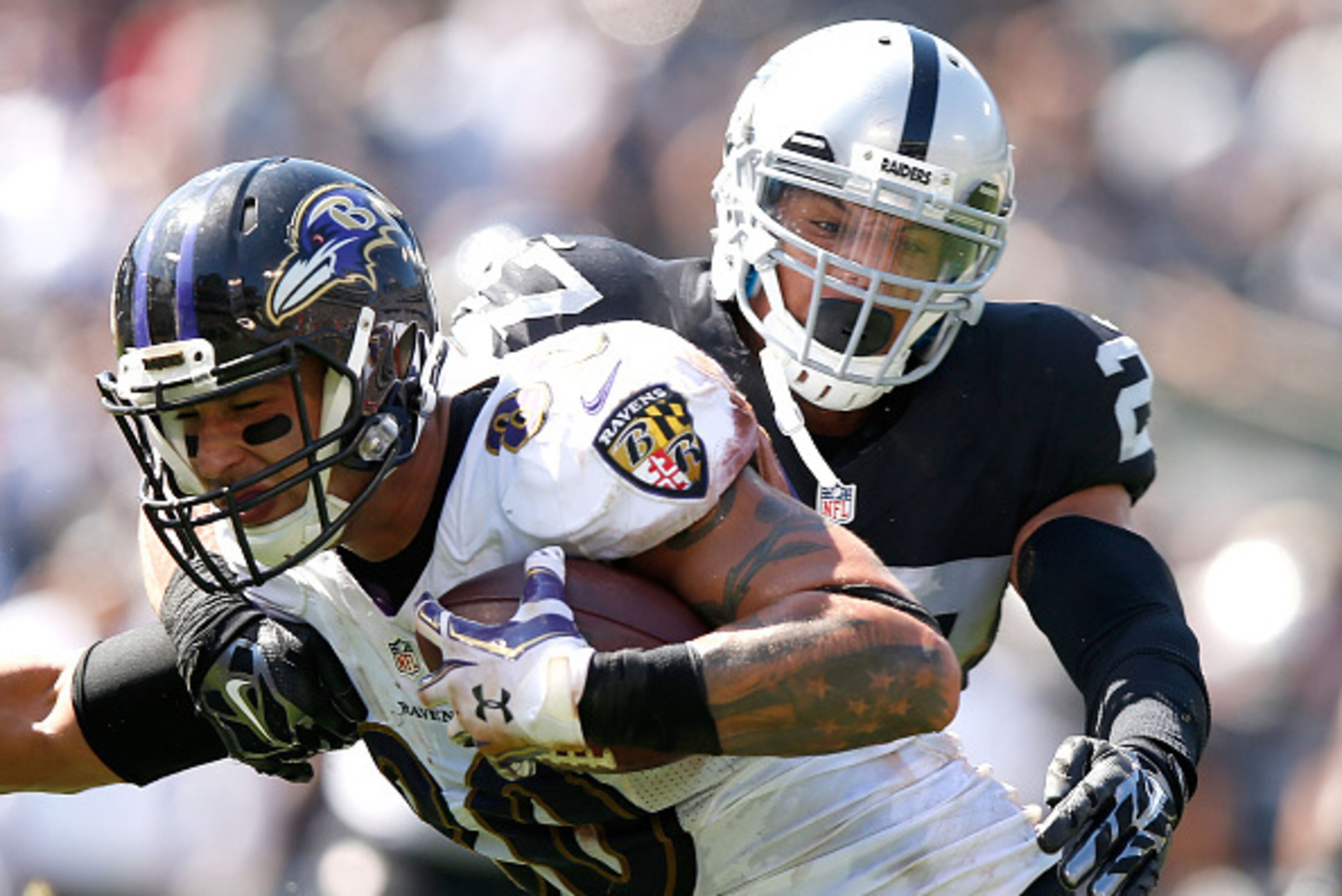 OAKLAND, CA - SEPTEMBER 20:  Crockett Gillmore #80 of the Baltimore Ravens carries for a touchdown against the block of Taylor Mays #27 of the Oakland Raiders in the second quarter against the Oakland Raiders at Oakland-Alameda County Coliseum on Septembe