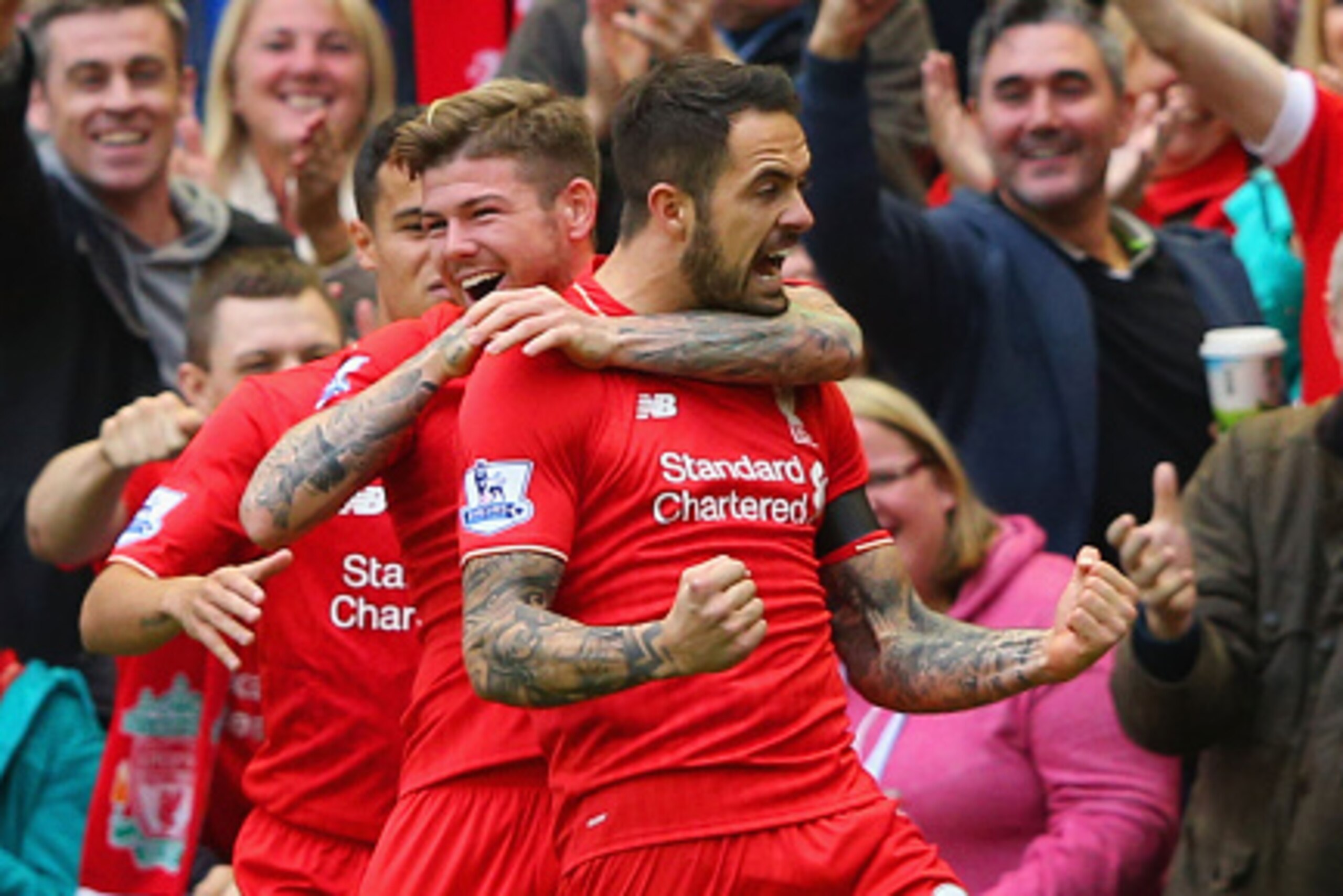 LIVERPOOL, ENGLAND - SEPTEMBER 20:  Danny Ings of Liverpool (R) celebrates with team mates Alberto Moreno and Philippe Coutinho as he scores their first goal during the Barclays Premier League match between Liverpool and Norwich City at Anfield on Septemb
