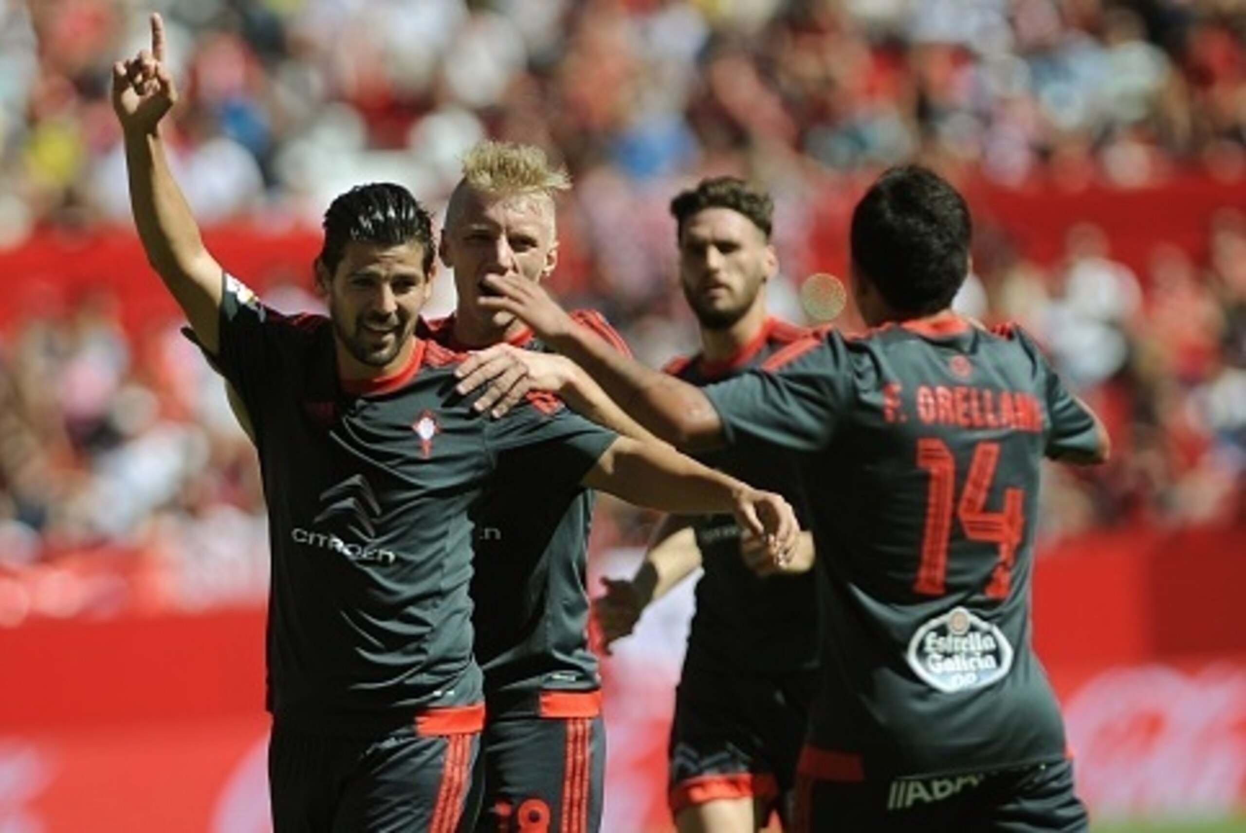Celta Vigo's forward  Nolito (L) celebrates a goal with Celta Vigo's Danish defender Daniel Wass (2nd L) during the Spanish league football match Sevilla FC vs RC Celta de Vigo at the Ramon Sanchez Pizjuan stadium in Sevilla on September 20, 2015.   AFP P