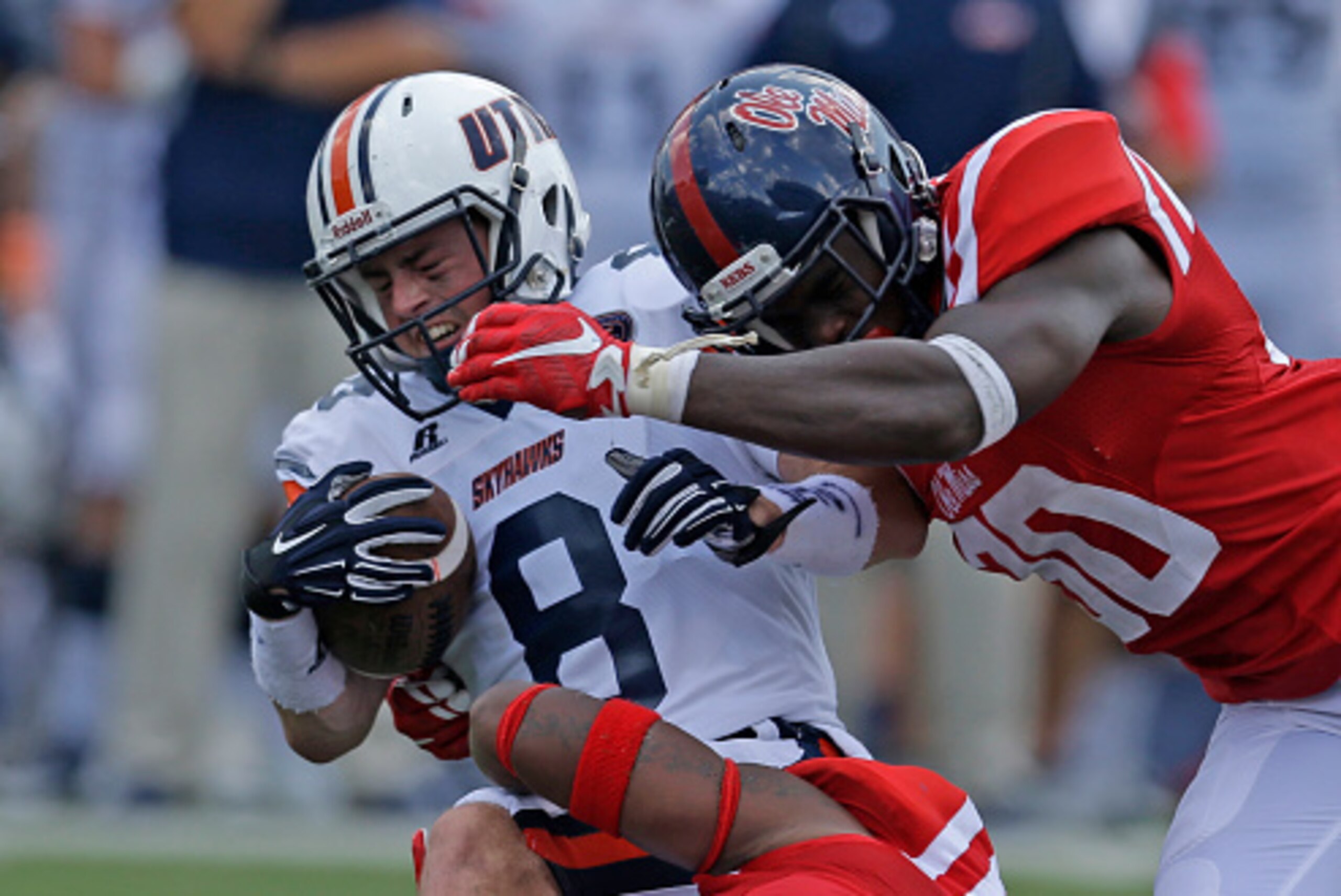 OXFORD MS -SEPTEMBER 5:  Wide receiver William Tanner #8 of the Tennessee Martin Skyhawks is tackled by linebacker Temario Strong #32 of the Mississippi Rebels and defensive back A.J. Moore #30 during the second half of a NCAA college football game at Vau