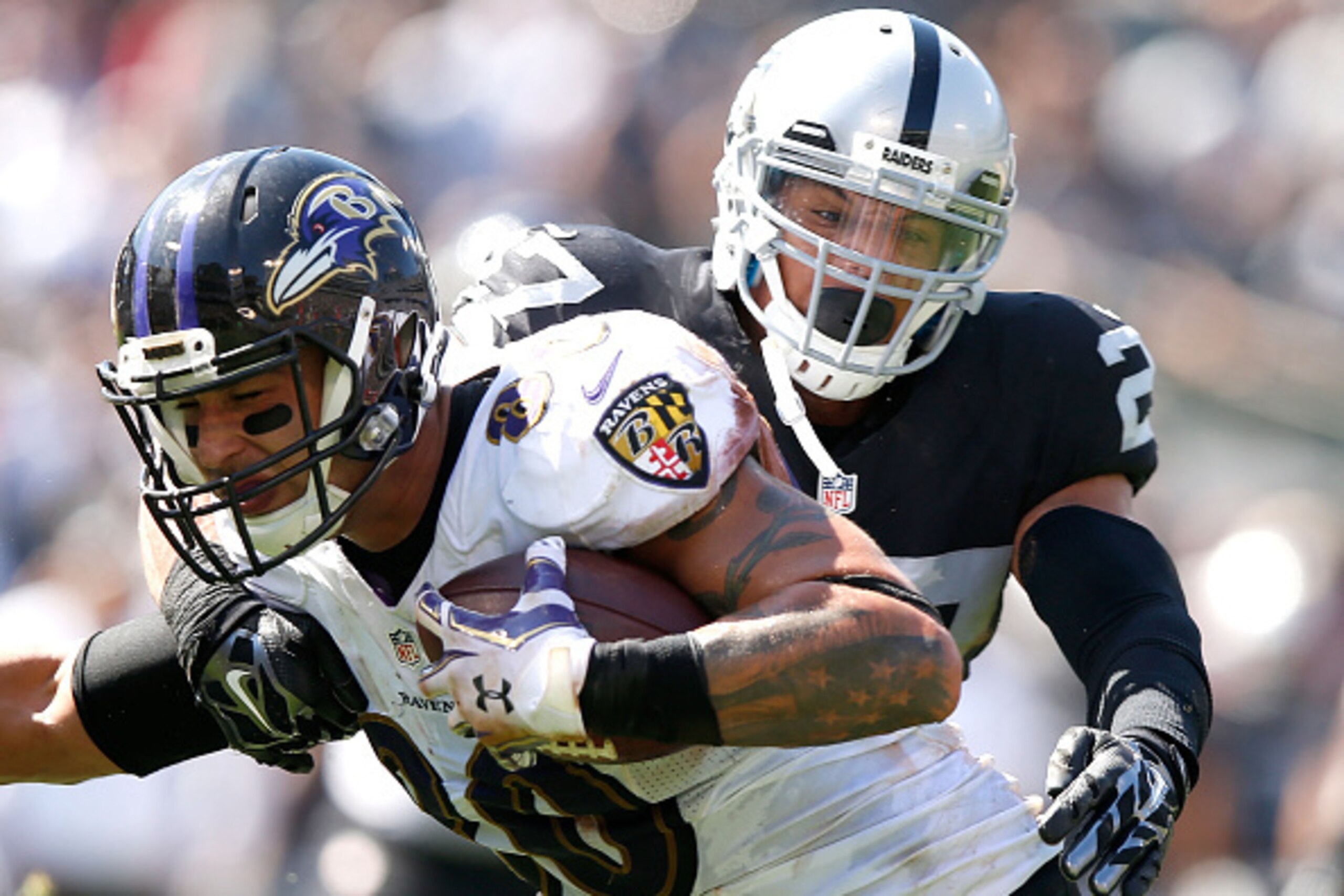 OAKLAND, CA - SEPTEMBER 20:  Crockett Gillmore #80 of the Baltimore Ravens carries for a touchdown against the block of Taylor Mays #27 of the Oakland Raiders in the second quarter against the Oakland Raiders at Oakland-Alameda County Coliseum on Septembe