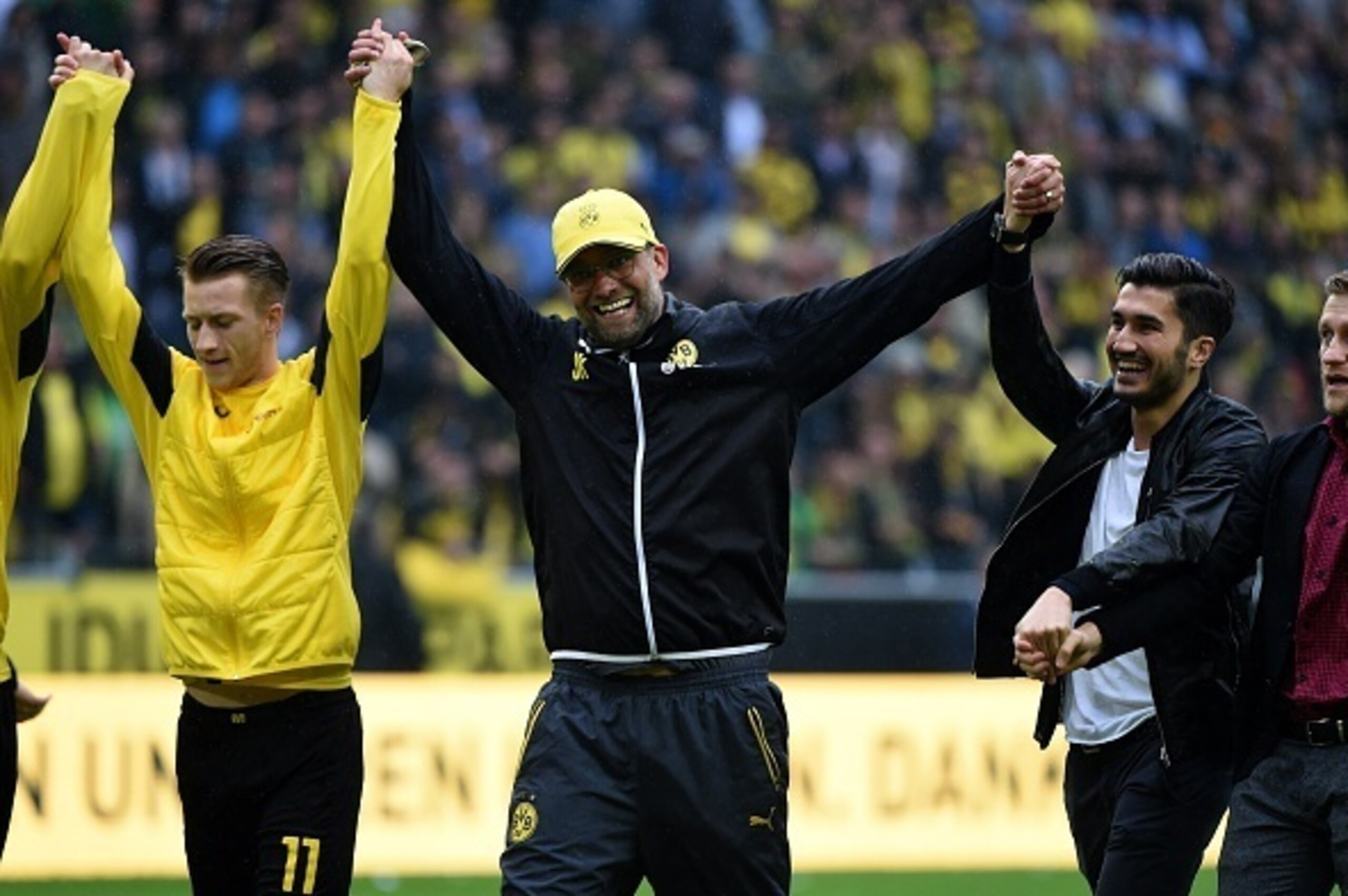 Dortmund's head coach Juergen Klopp (C) and Dortmund's players celebrate after the German first division Bundesliga football match between Borussia Dortmund and SV Werder Bremen at the Signal Iduna Park in Dortmund, western Germany on May 23, 2015. Dortmu