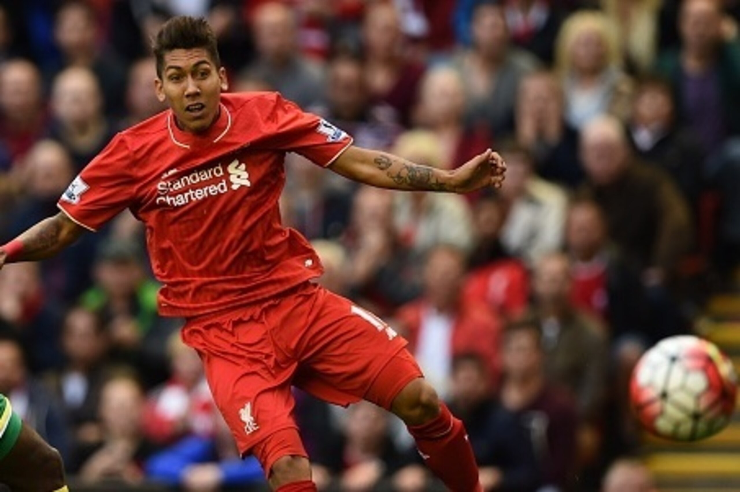 Liverpool's Brazilian midfielder Roberto Firmino (R) shoots past Norwich City's Cameroonian defender Sebastien Bassong during the English Premier League football match between Liverpool and Norwich City at the Anfield stadium in Liverpool, north-west Engl