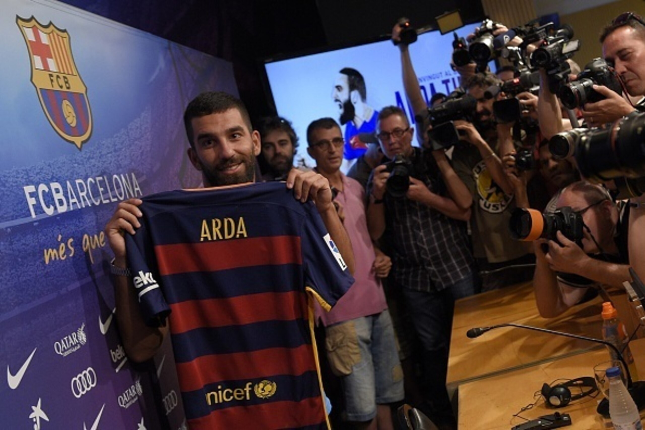 Barcelona's new player Turkish Arda Turan (L) shows his new jersey at the Camp Nou stadium in Barcelona, after signing his new contract with the Catalan club, on July 10, 2015. Barcelona will keep more than 60 million euros ($65 million) of talent on the Barcelona's new player Turkish Arda Turan (L) shows his new jersey at the Camp Nou stadium in Barcelona, after signing his new contract with the Catalan club, on July 10, 2015. Barcelona will keep more than 60 million euros ($65 million) of talent on the