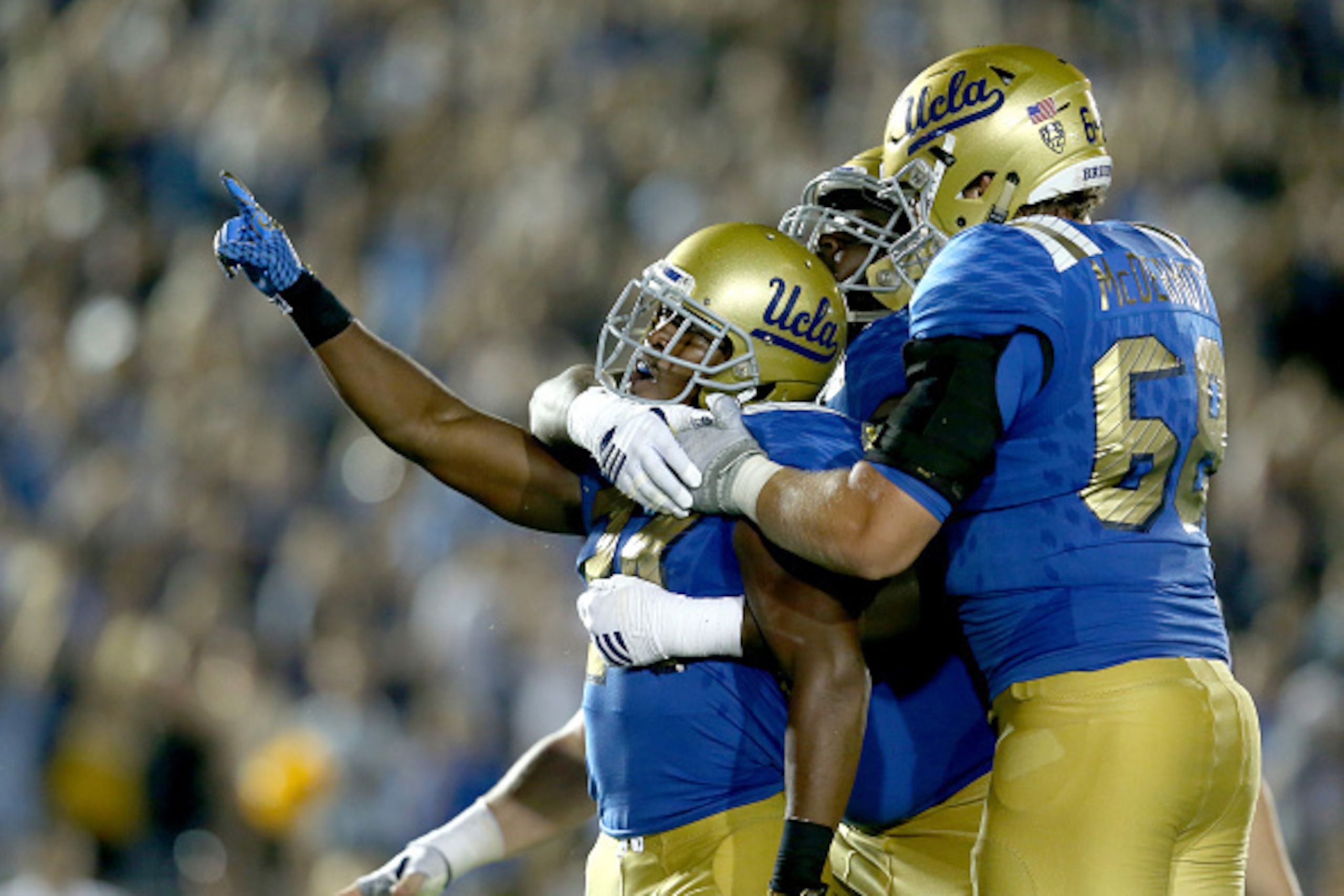 PASADENA, CA - SEPTEMBER 19:  Paul Perkins #24 of the UCLA Bruins celebrates with teammates after his five yard touchdown run in the third quarter against the BYU Cougars at the Rose Bowl on September 19, 2015 in Pasadena, California.  UCLA won 24-23.  (P