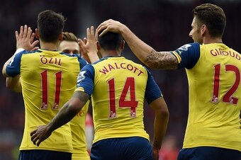 Arsenal's English midfielder Theo Walcott (C) celebrates after scoring from a deflection with Arsenal's German midfielder Mesut Ozil (L) and Arsenal's French striker Olivier Giroud during the English Premier League football match between Manchester United