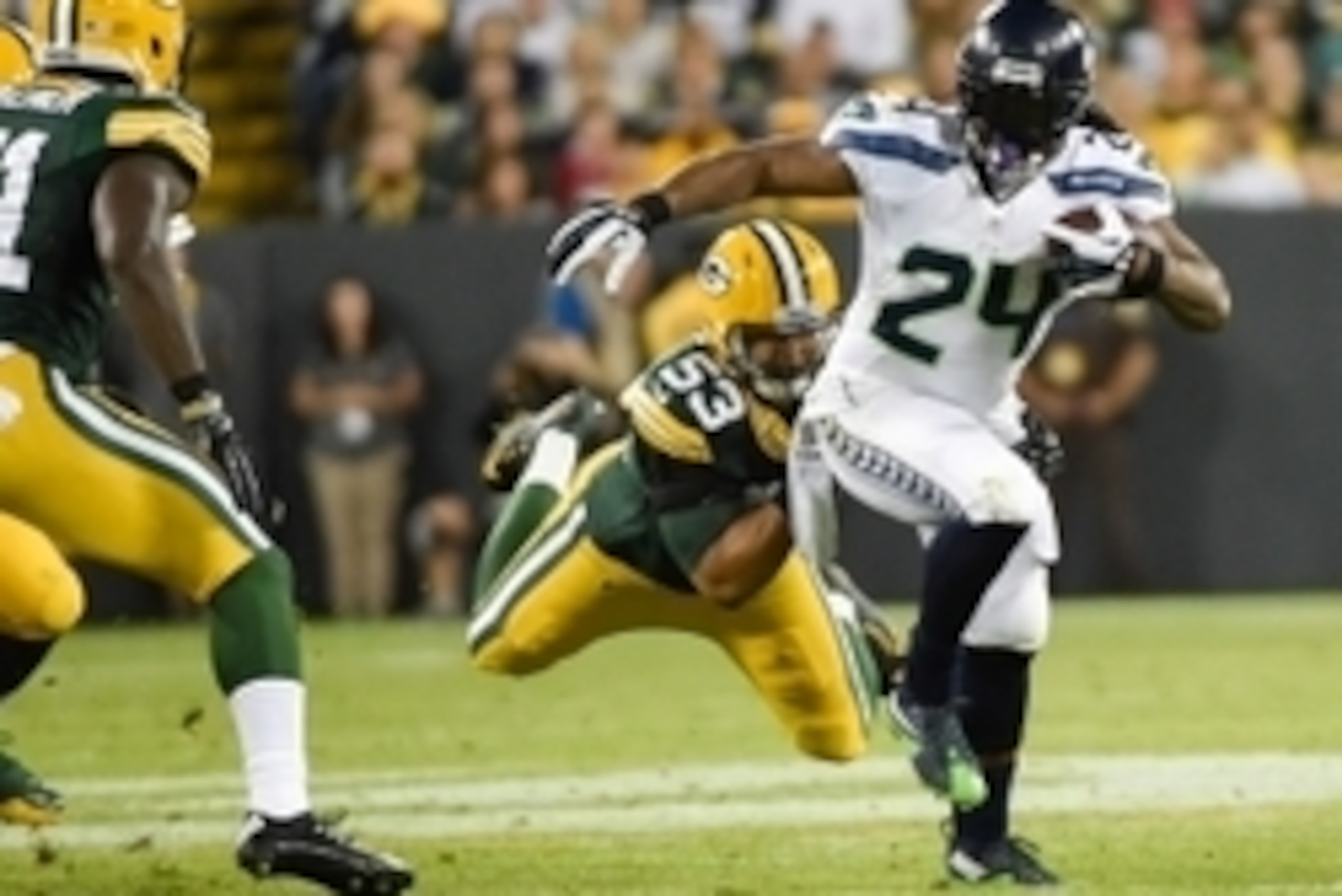 Sep 20, 2015; Green Bay, WI, USA; Seattle Seahawks running back Marshawn Lynch (24) tries to break free from Green Bay Packers linebacker Nick Perry (53) in the second quarter at Lambeau Field. Mandatory Credit: Benny Sieu-USA TODAY Sports
