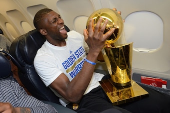 OAKLAND, CA - JUNE 17:  Festus Ezeli #31 of the Golden State Warriors holds the trophy on the plane as the team travels home from Cleveland after winning the 2015 NBA Finals on June 17, 2015 in Oakland, California. NOTE TO USER: User expressly acknowledge