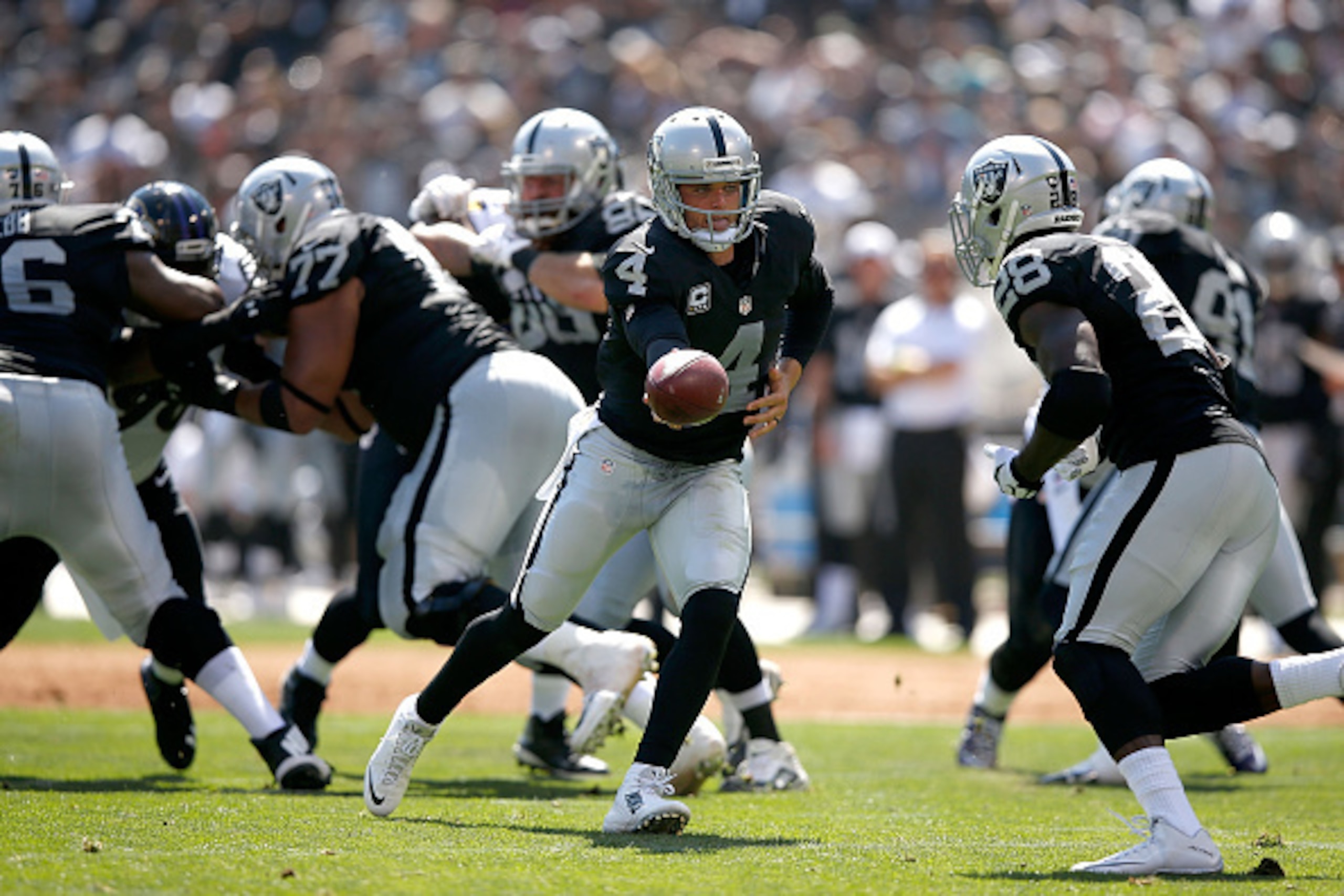 OAKLAND, CA - SEPTEMBER 20:  Derek Carr #4 of the Oakland Raiders hands off to Latavius Murray #28 of the Oakland Raiders in the first quarter against the Baltimore Ravens at Oakland-Alameda County Coliseum on September 20, 2015 in Oakland, California.  (